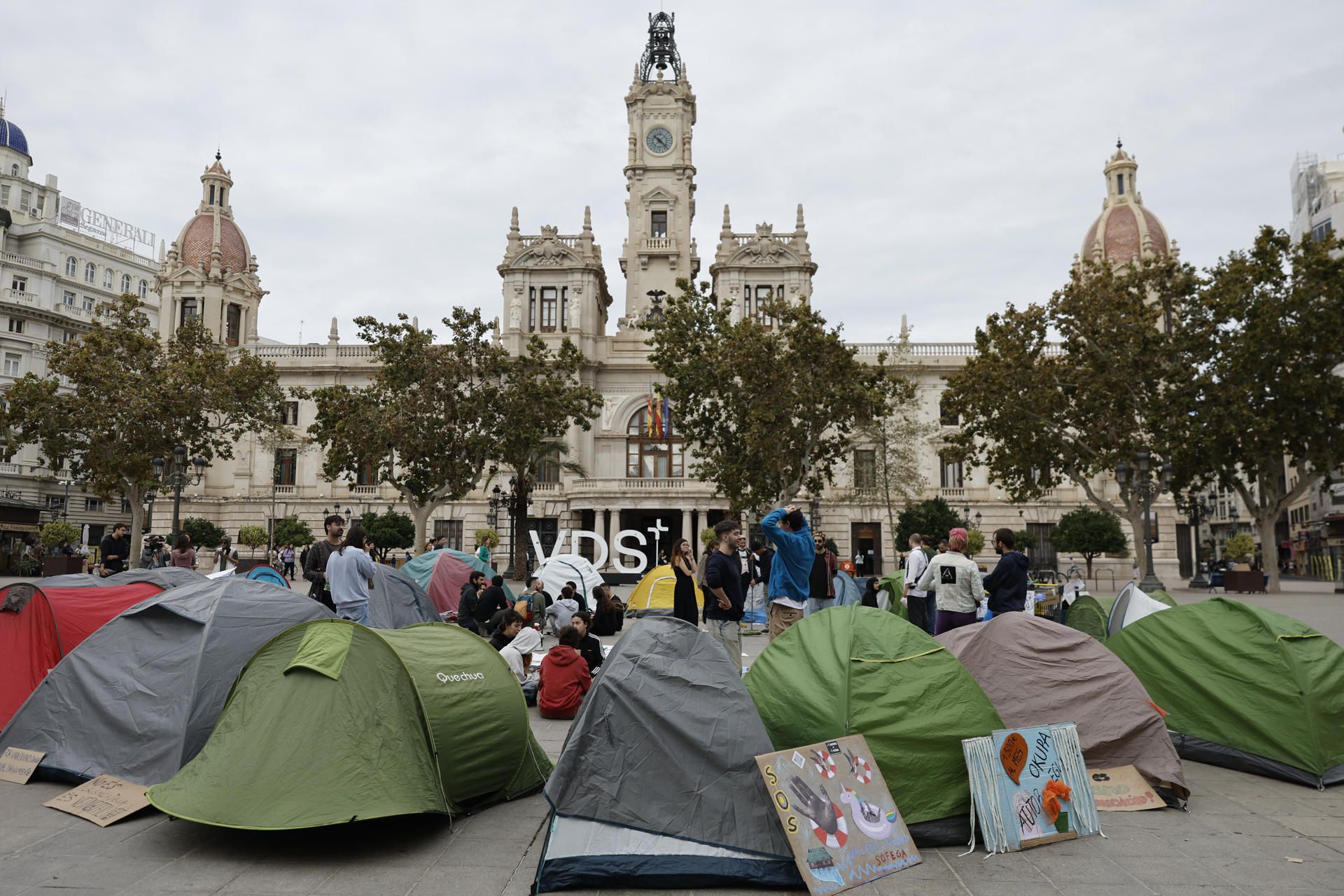 Vista este domingo de las tiendas de campaña que varios manifestantes plantaron ayer en la plaza de Ayuntamiento en Valencia para reclamar el derecho a la vivienda y contra la turistificación de la ciudad bajo el lema 'València s'ofega' (València se ahoga), que rememora la riada que inundó la ciudad el 14 de octubre de 1957. (EFE/ Kai Försterling)