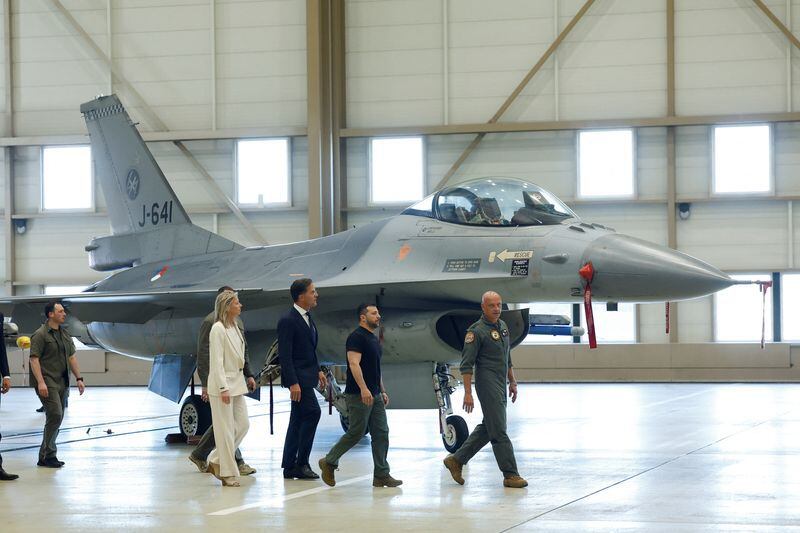 El presidente ucraniano Volodimir Zelensky y el primer ministro neerlandés Mark Rutte caminando cerca de un F-16, en Eindhoven este domingo (REUTERS/Piroschka van de Wouw)