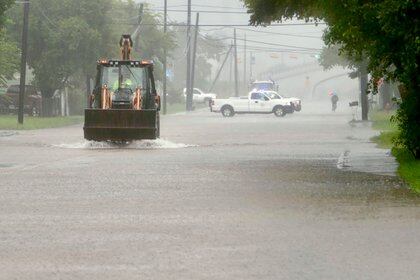 Backhoe dirixe un inundado S. Velasco Blvd. en Freeport, Texas, mércores, setembro. 18, 2019. Segundo a policía de Freeport, os impactos das casas foron mínimas ata agora cun dos principais problemas que as persoas que conducen demasiado rápido a través da auga e empuxando as inundacións en casas coa súa estela. (Mark Mulligan / Houston Chronicle a través de AP)