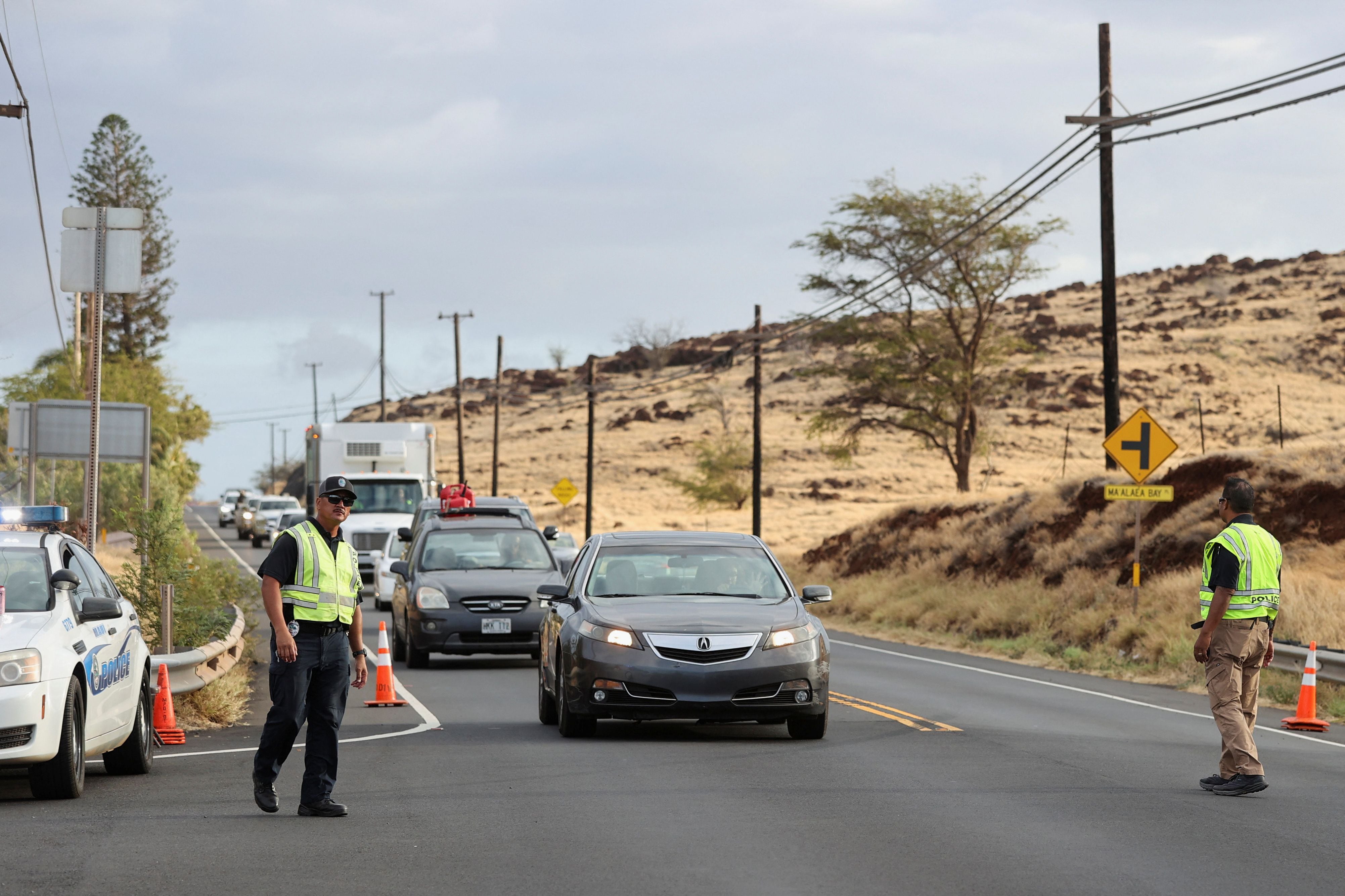 La policía dirige los coches procedentes del oeste de Maui, donde los incendios forestales destruyeron gran parte de la histórica ciudad de Lahaina, en un control de carretera en Kahului, Maui, Hawai, EE.UU. 10 de agosto 2023. REUTERS/Marco García