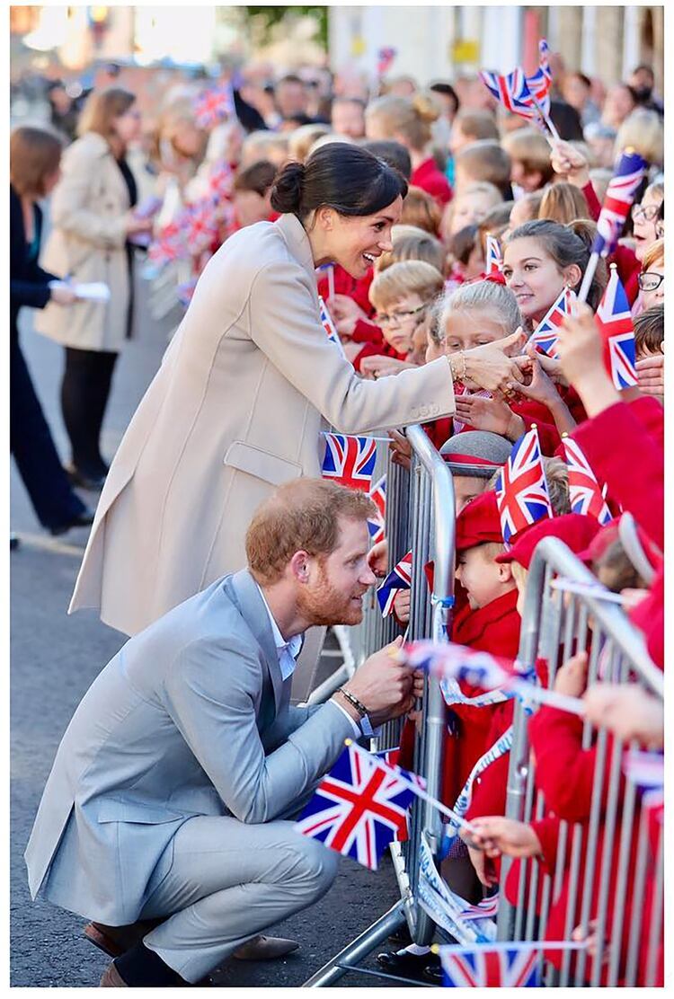 Harry y Meghan saludando a sus pequeños fans durante una visita a Sussex en octubre pasado