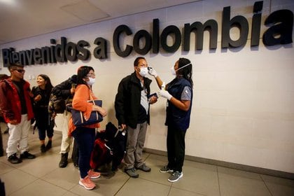 Medical personnel from the Ministry of Health check the temperature of passengers, amid the worldwide coronavirus outbreak, upon arrival at El Dorado International Airport in Bogotá, Colombia, March 5, 2020. REUTERS / Leonardo Munoz.  NOT RESALE.  NO FILES