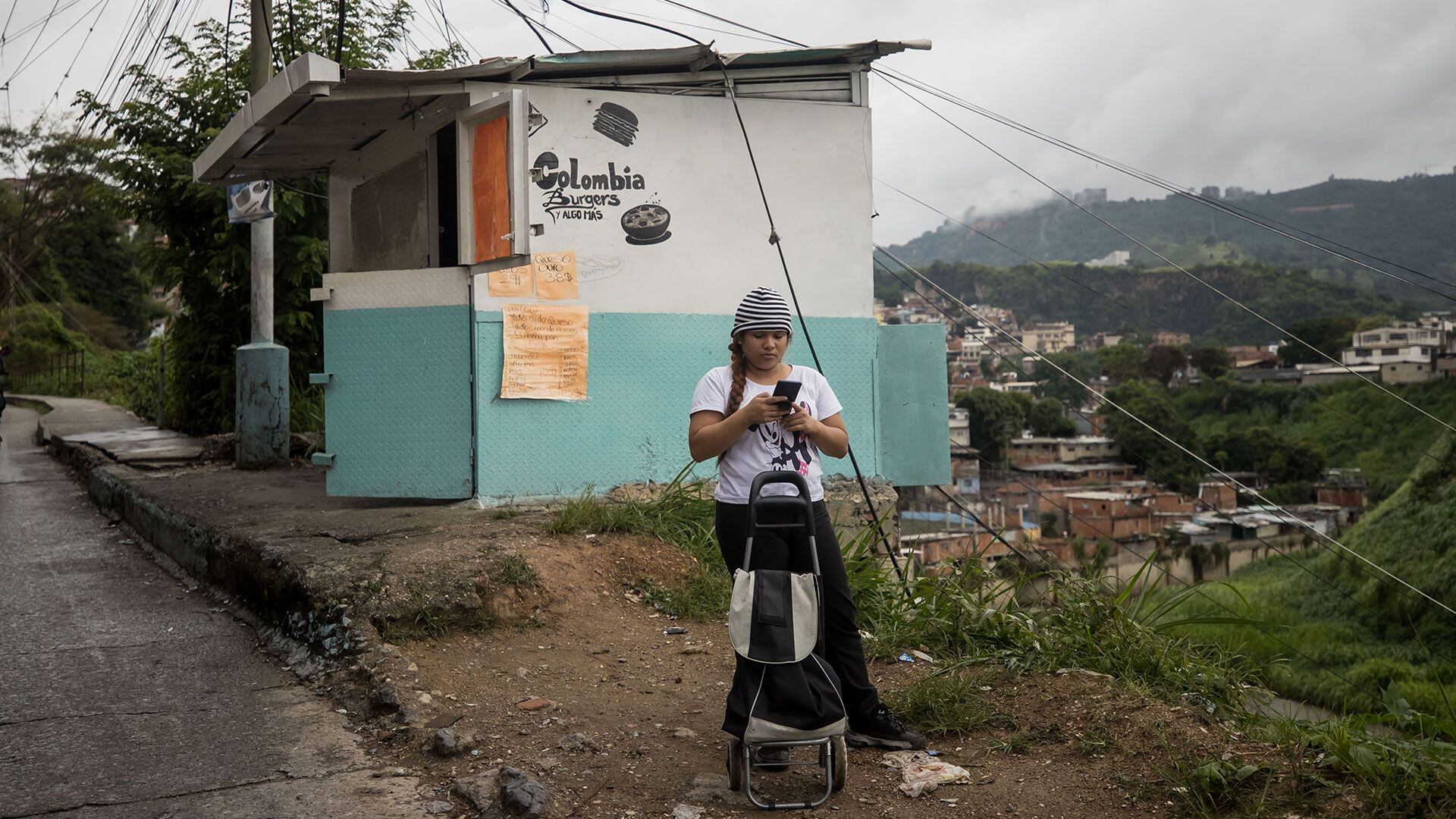 Una joven revisa su celular en una barriada de Caracas (EFE/MIGUEL GUTIÉRREZ)
