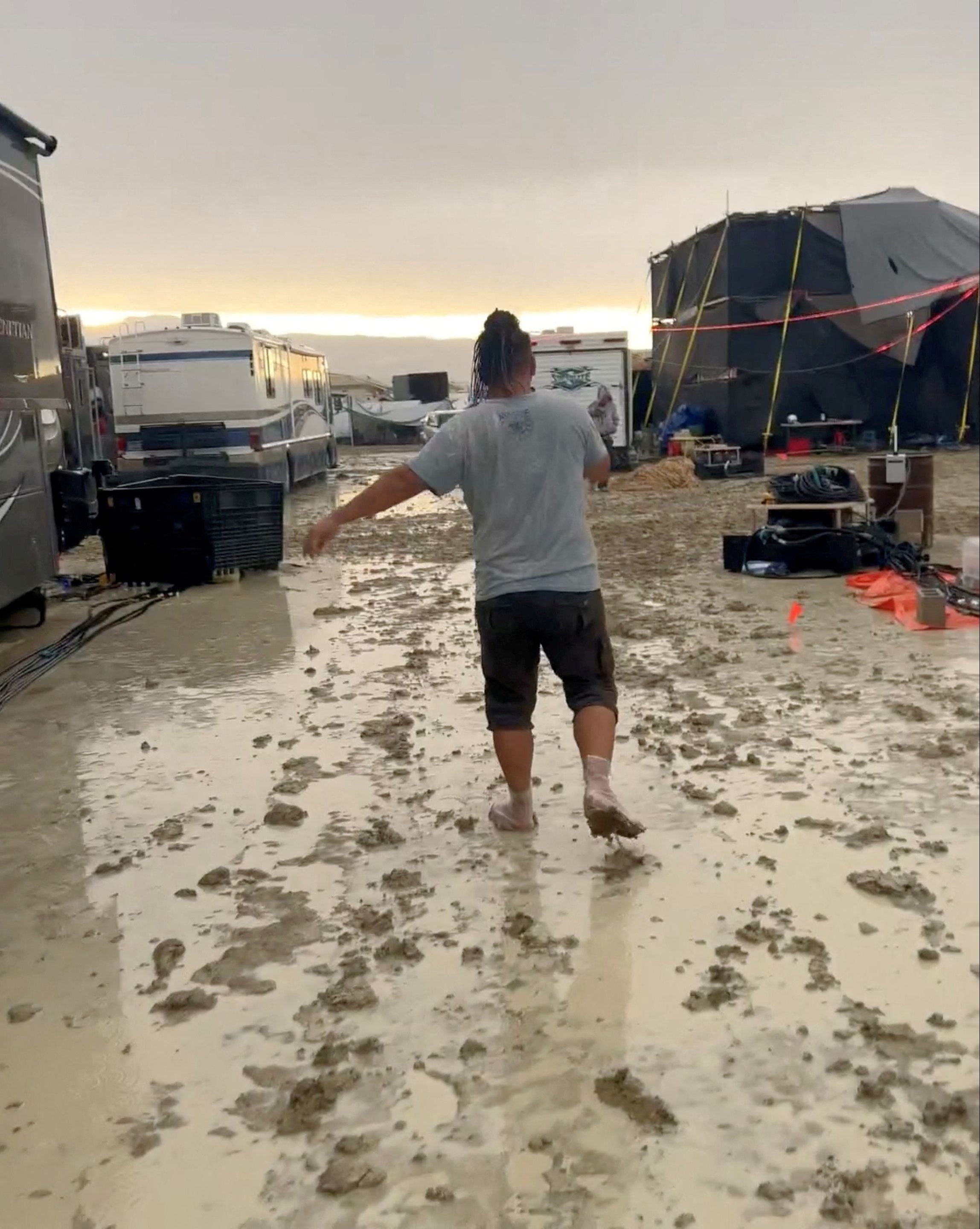 Un asistente camina por el barro después de una fuerte lluvia, durante el evento Burning Man. Evi Airy vía REUTERS