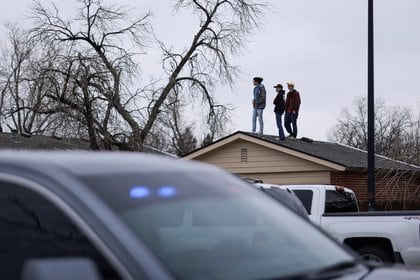 La gente se para en un techo en el perímetro del lugar de la masacre del supermercado de King Soopers en Boulder, Colorado (Reuters)