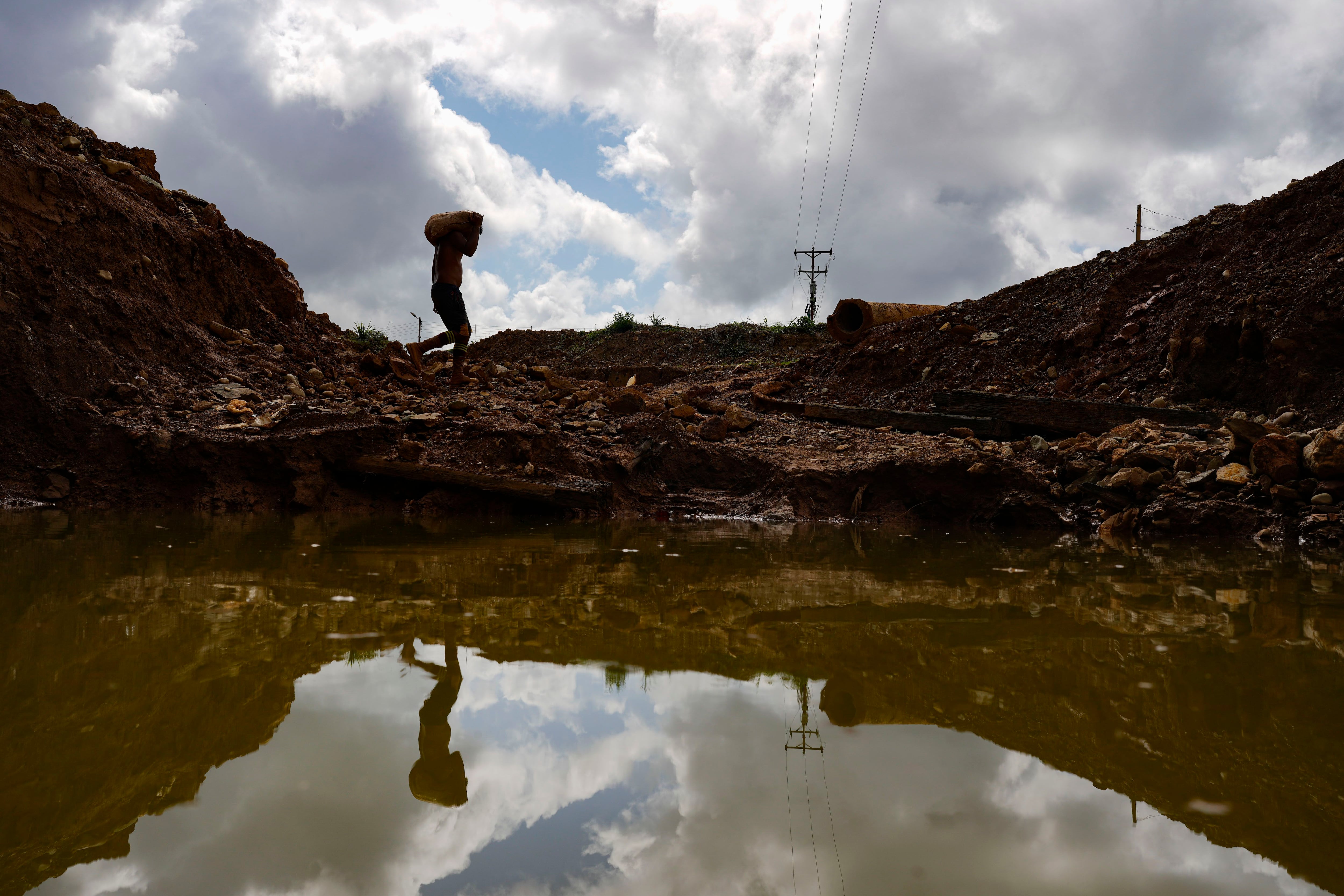 Un minero lleva un saco de rocas a un molino en una mina en El Callao, estado de Bolívar, Venezuela (AP/Matias Delacroix)