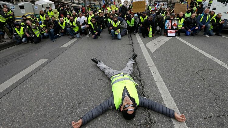 Una persona tendida sobre la calle (AP Photo/Claude Paris)