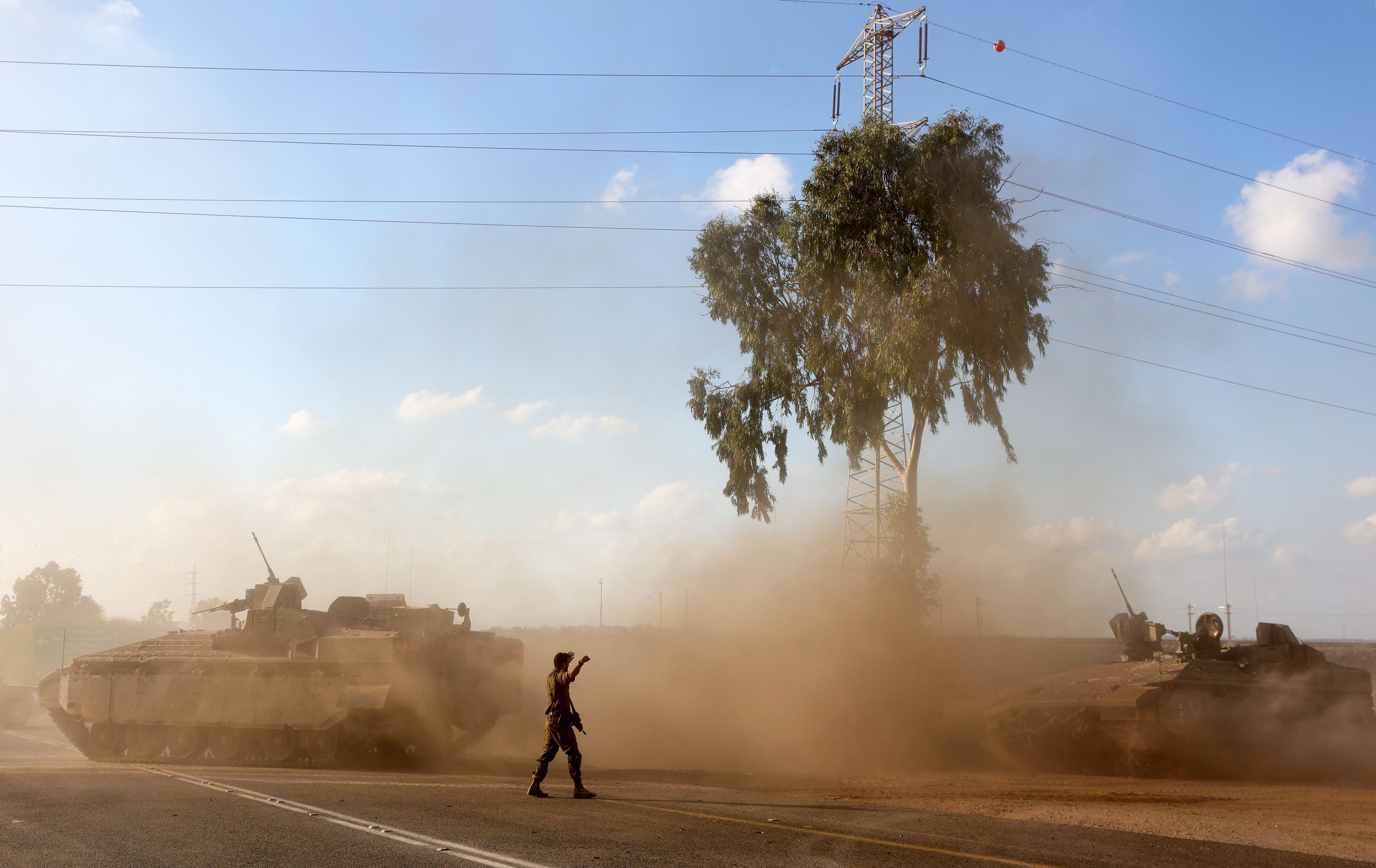 Vehículos blindados de transporte de tropas israelíes maniobran en una zona de la frontera con Gaza, mientras continúa la evacuación de los palestinos en la Franja ante el probable comienzo de la guerra