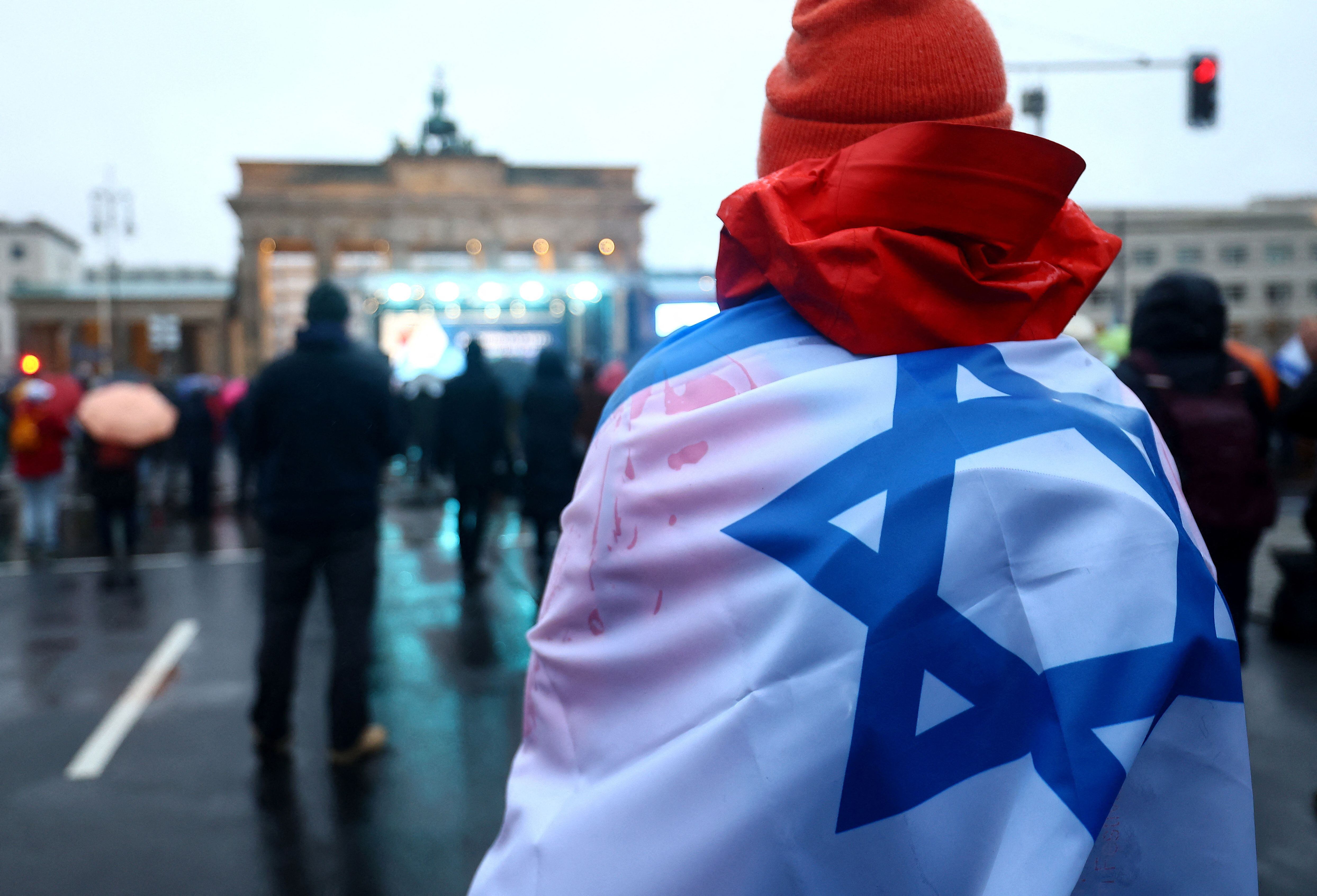 Una persona porta una bandera israelí durante una protesta contra el antisemitismo en la Puerta de Brandeburgo, en medio del actual conflicto entre Israel y el grupo terrorista palestino Hamas, en Berlín, Alemania, 10 de diciembre de 2023.  REUTERS/Lisi Niesner