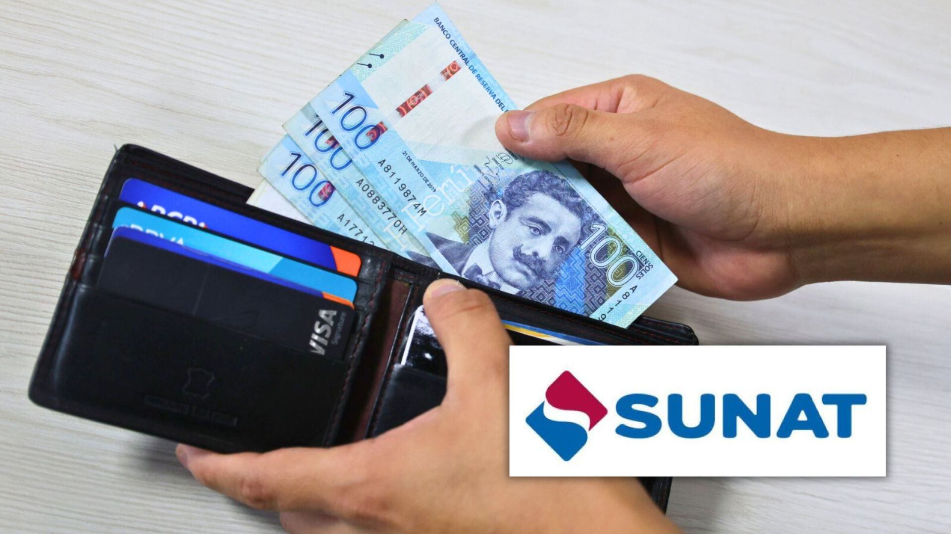 Mano poniendo billetes de 100 soles en billetera con logo de la Sunat