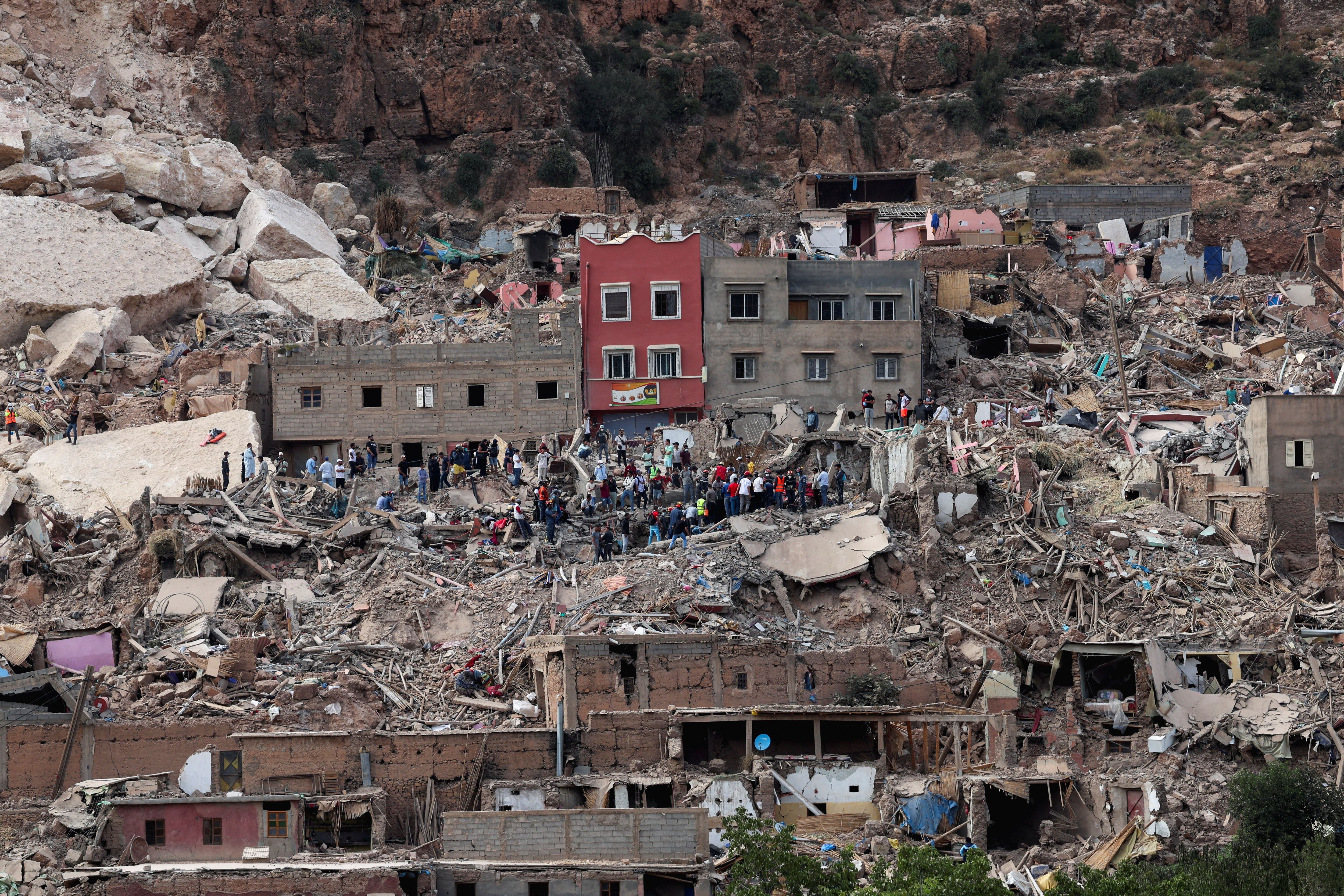 Un grupo de personas sobre los escombros del pueblo de Imi N'Tala  (REUTERS/Emilie Madi)