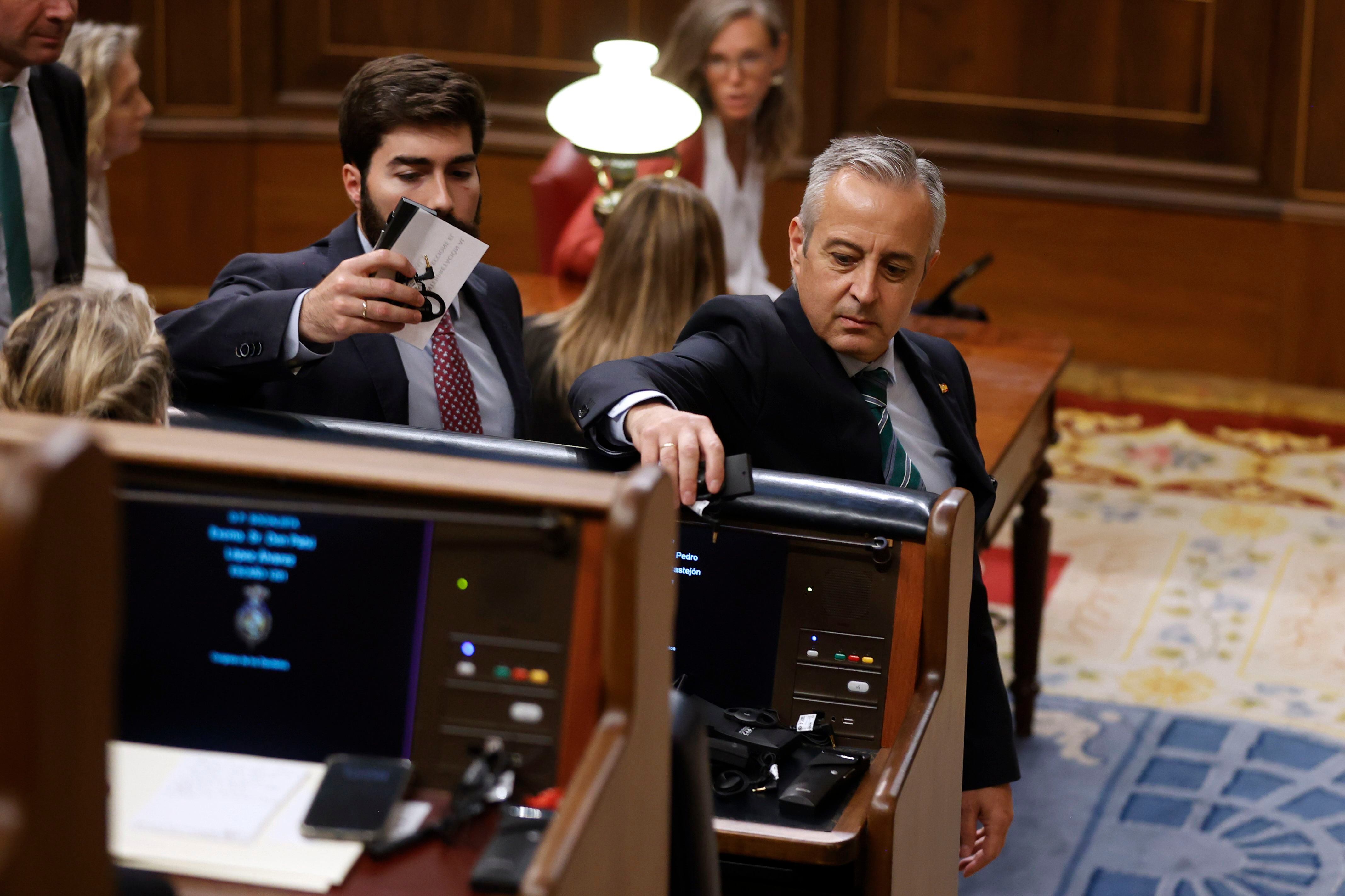 Los diputados de Vox depositan sus auriculares de traducción en el escaño del presidente de Pedro Sánchez. (EFE/Juan Carlos Hidalgo)