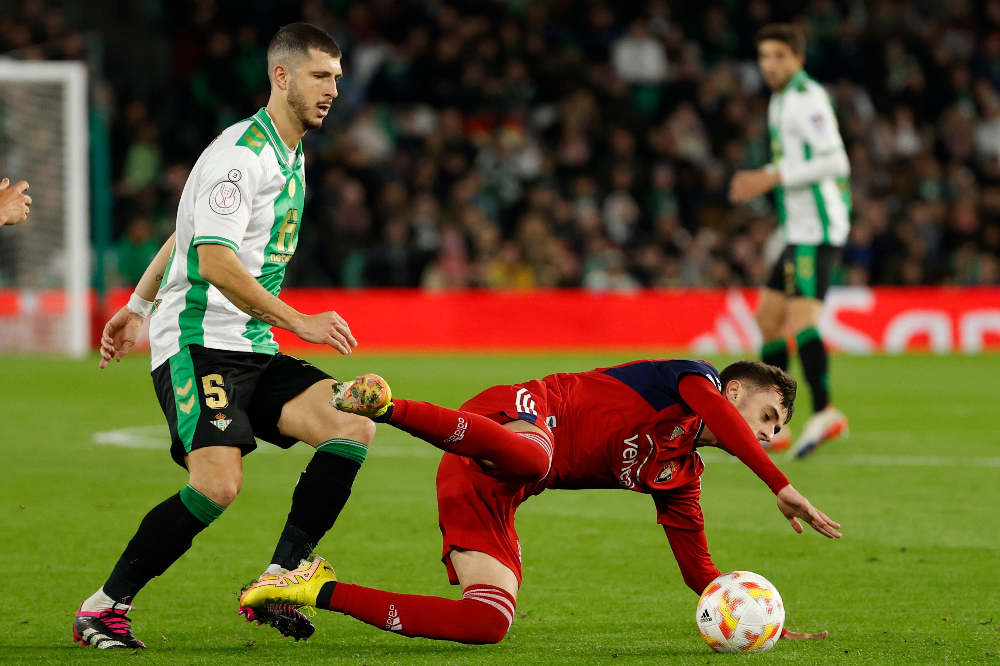 El mediocampista argentino del Betis Guido Rodríguez disputa el balón con un jugador de Osasuna, en el estadio Benito Villamarín (EFE/ Julio Muñoz)
