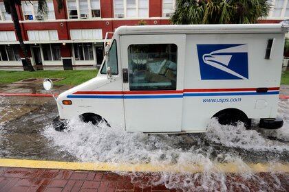 A postal truck drives through floodwaters from Tropical Depression Imelda, Wednesday, Set 18, 2019, in Galveston, Texas. (AP Photo / David J. Phillip)