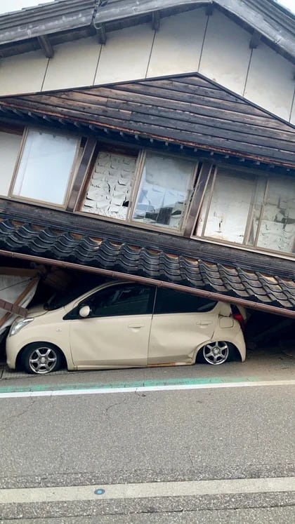 Un coche atrapado bajo una casa derrumbada tras un terremoto, en la ciudad de Shika, prefectura de Ishikawa. (Kyodo via REUTERS)