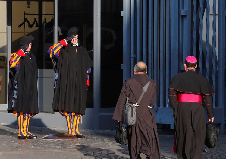 Guardias suizos saludan a dos participantes de la cumbre en el Vaticano (REUTERS/Remo Casilli)