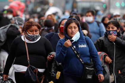 Vendedoras ambulantes caminan el pasado 12 de junio en una calle de Lima (Perú). EFE/Paolo Aguilar
