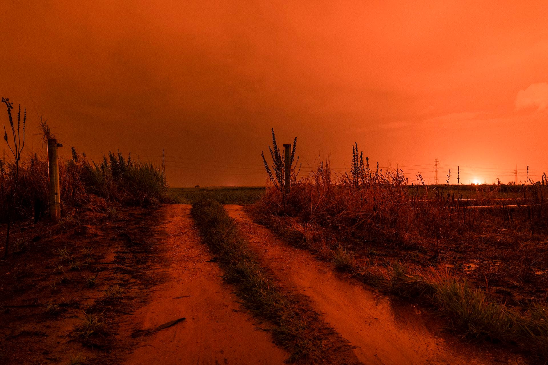 La carretera que conduce a Punta de Mata, iluminada por múltiples antorchas de quema, que en esta parte de Venezuela arden día y noche (NYT)