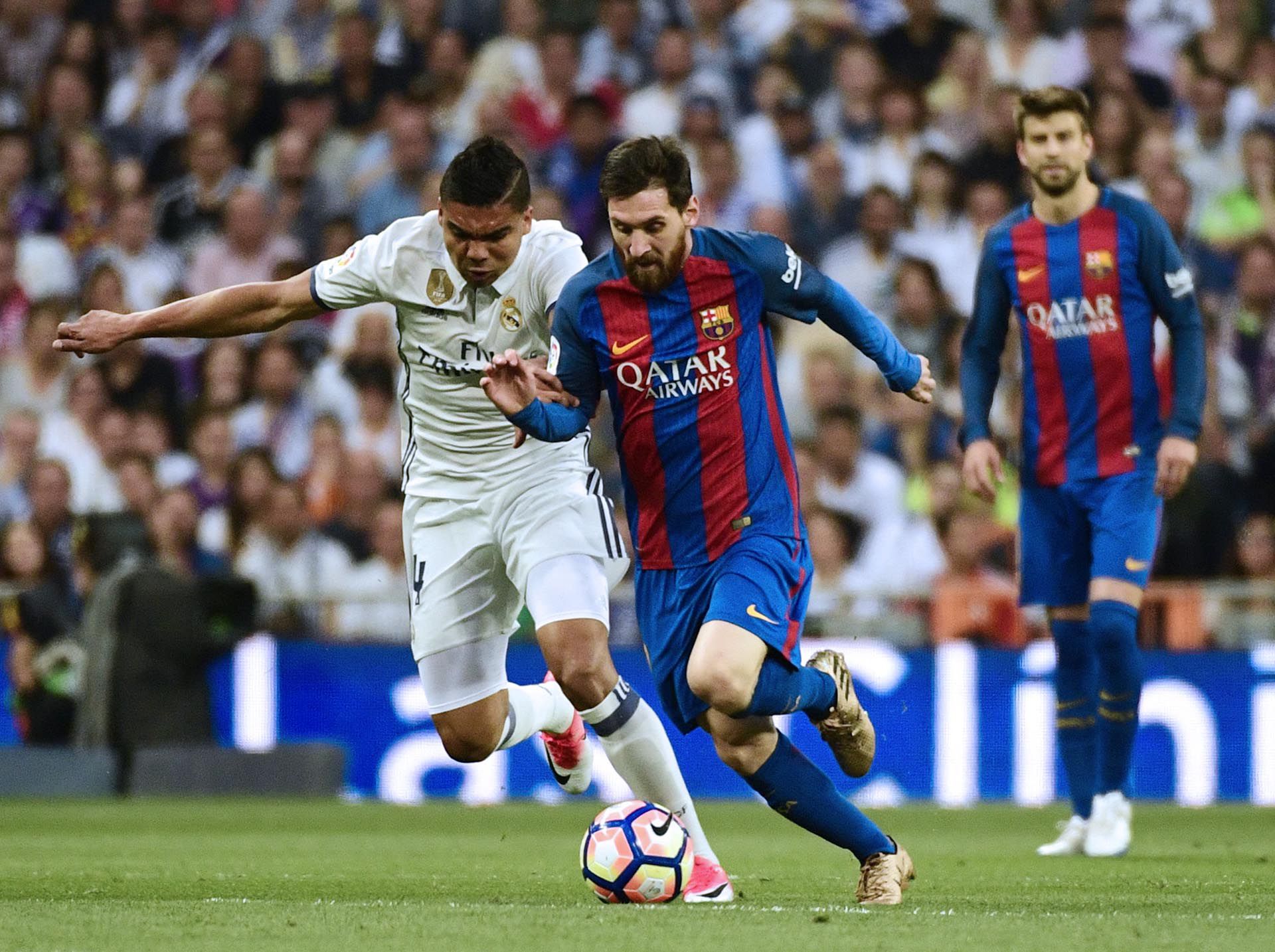  Lionel Messi perseguido por Casemiro en el clásico español