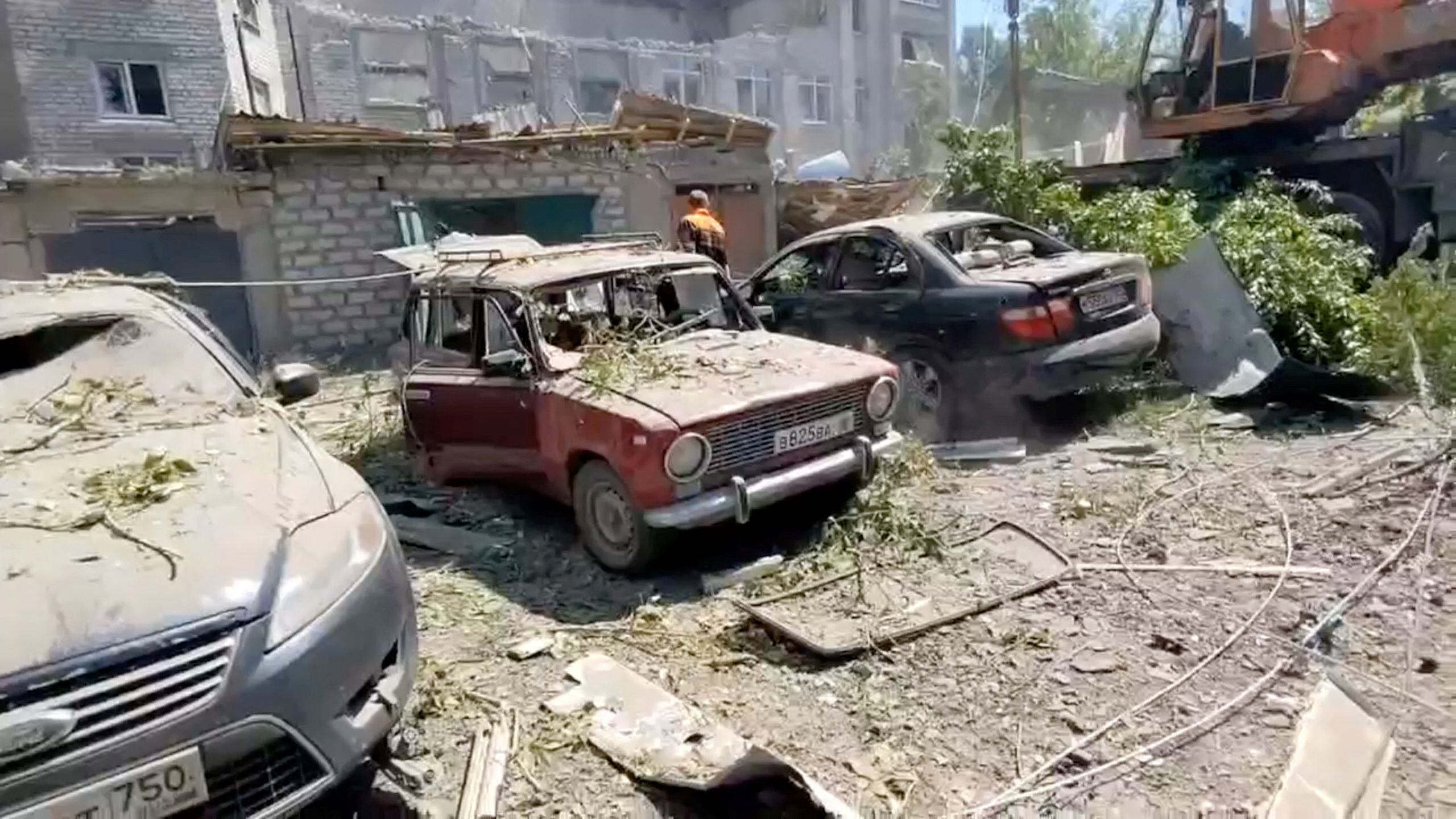 Una vista muestra un edificio y coches destruidos en el asentamiento de Yubileiny, en la región de Luhansk (Reuters)