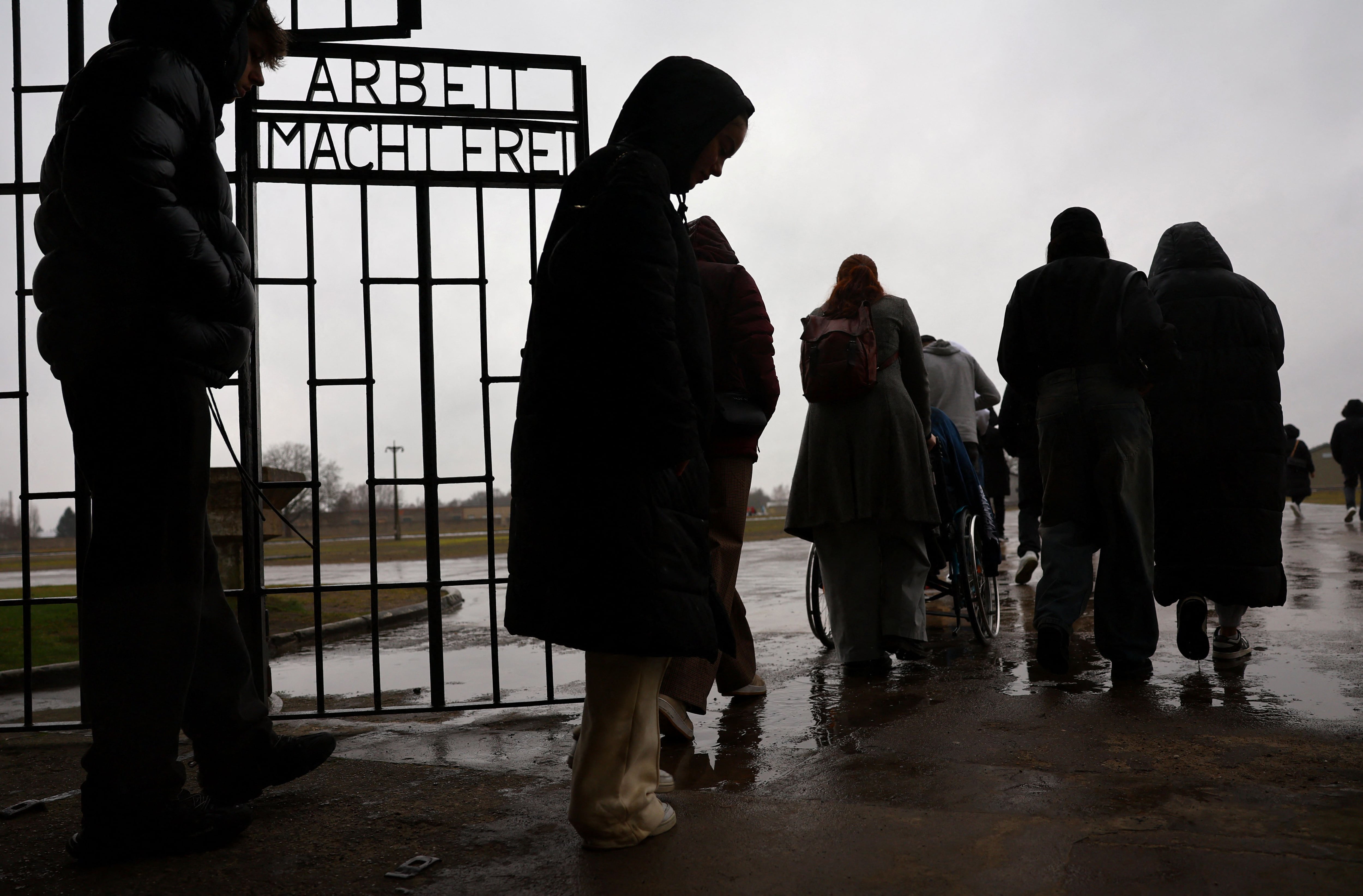 Visitantes caminan junto a las palabras "Arbeit Macht Frei" (El trabajo hace libre) mientras pasan por la puerta de entrada principal del antiguo campo de concentración nazi de Sachsenhausen en Oranienburg, Alemania 26 de enero de 2024. REUTERS/Fabrizio Bensch