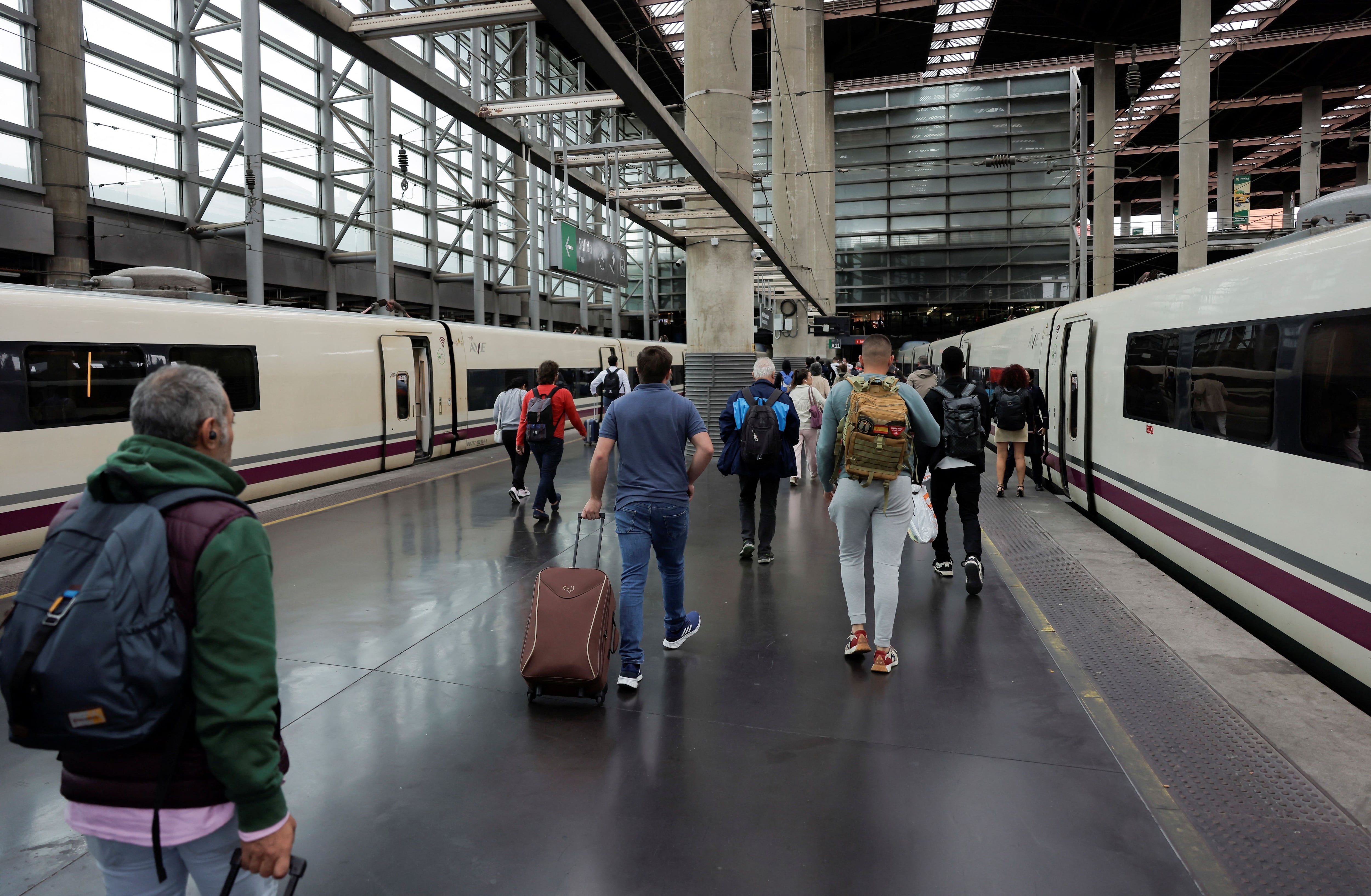 Passengers walk on the platform between two AVE high-speed (Talgo 350) trains as they arrive at the Atocha train station, in Madrid, Spain, October 14, 2024. REUTERS/Jon Nazca