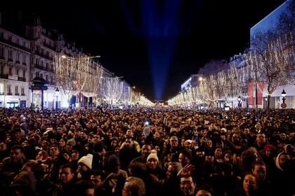 La gente se reúne en la avenida de los Campos Elíseos durante las celebraciones de Nochevieja cerca del Arco del Triunfo en París, Francia, el 31 de diciembre de 2023. REUTERS/Benoit Tessier