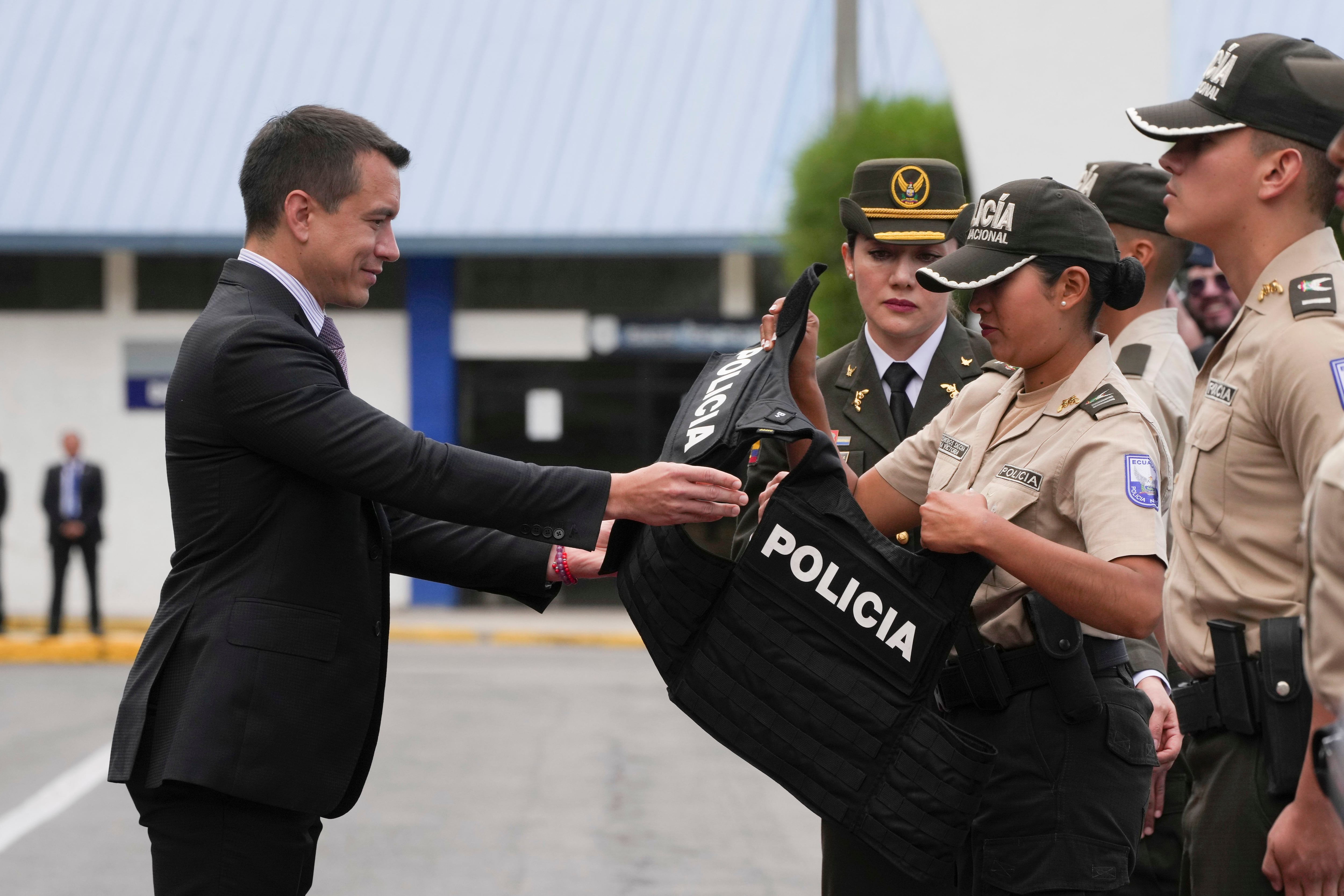 El presidente de Ecuador, Daniel Noboa, sujeta un chaleco antibalas en una ceremonia de entrega de equipamiento a la policía (AP Foto/Dolores Ochoa)