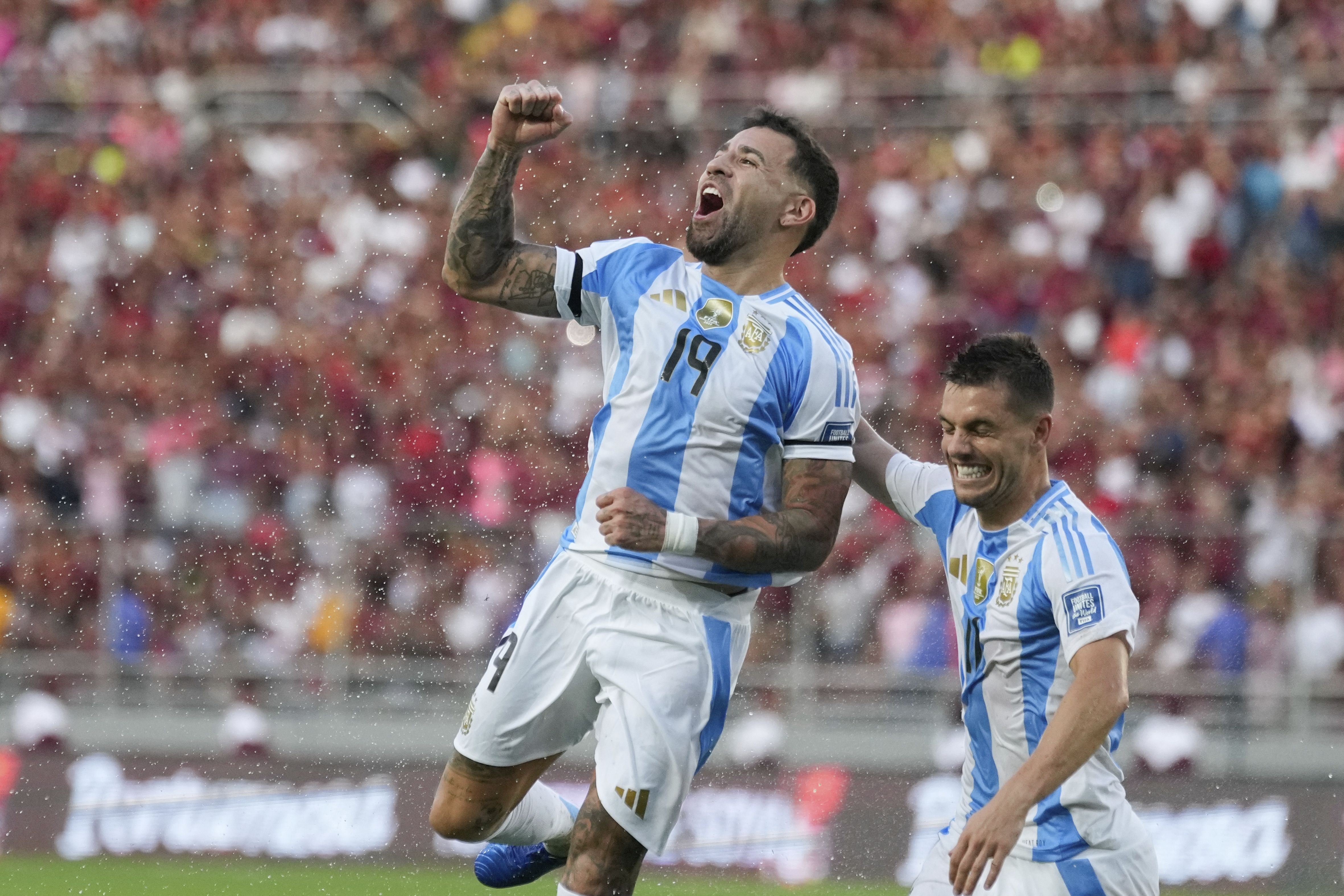 Nicolás Otamendi, abrazado por Giovani Lo Celso, festeja el gol que le convirtió a Venezuela por Eliminatorias (AP Foto/Ariana Cubillos)