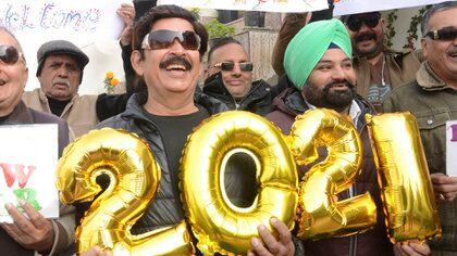 La gente sostiene pancartas y globos que forman el número 2021 durante las celebraciones del Año Nuevo en Amritsar, India. NARINDER NANU / AFP