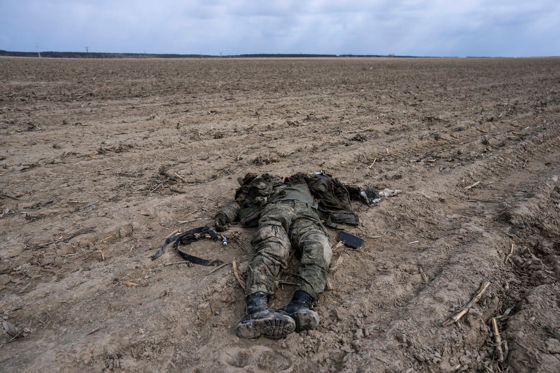 Ein russischer Soldat, der bei Kämpfen gegen die ukrainische Armee getötet wurde, liegt auf einem Maisfeld in Sytnyaky, am Stadtrand von Kiew, Ukraine, am Sonntag, 27. März 2022. Der ukrainische Präsident Volodymyr Zelenskyy warf dem Westen vor, keinen Mut zu haben, während sein Land darum kämpft, Russlands einfallende Truppen abzuwehren, und plädierte verärgert dafür, dass Kampfflugzeuge und Panzer eine Verteidigung in einem Konflikt aufrechterhalten, der in einen Zermürbungskrieg geführt hat. (AP Foto/Rodrigo Abd)