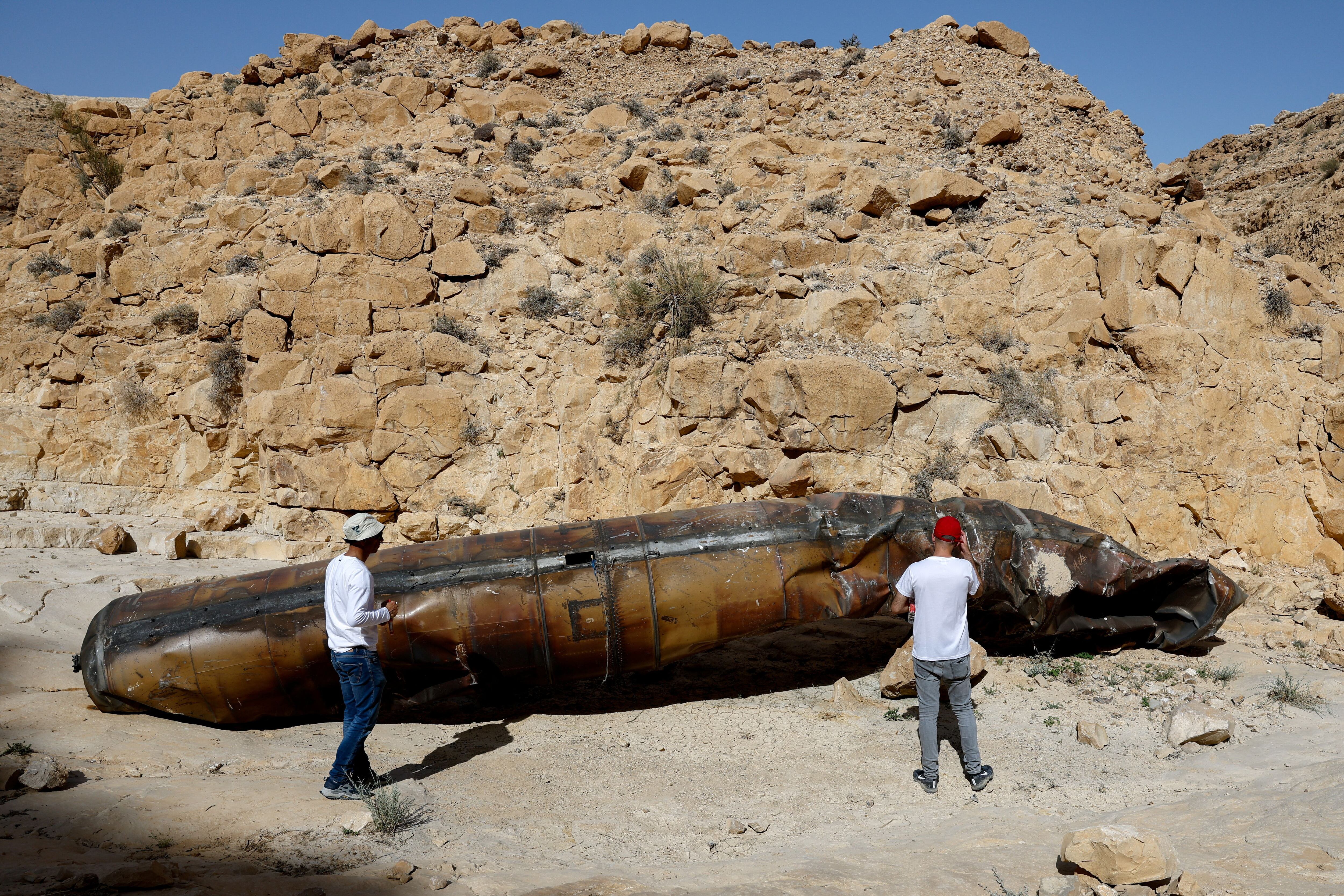 Miembros del personal militar vestidos de civil inspeccionan restos aparentes de un misil balístico que se encuentra en el desierto, tras un ataque masivo con misiles y drones por parte de Irán contra Israel, cerca de la ciudad sureña de Arad, Israel, el 24 de abril de 2024. REUTERS/Amir Cohen