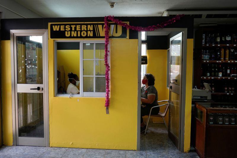 Una mujer se sienta dentro de una oficina de Western Union para recibir una remesa, en La Habana, Cuba, el 28 de octubre de 2020 (REUTERS/Alexandre Meneghini)