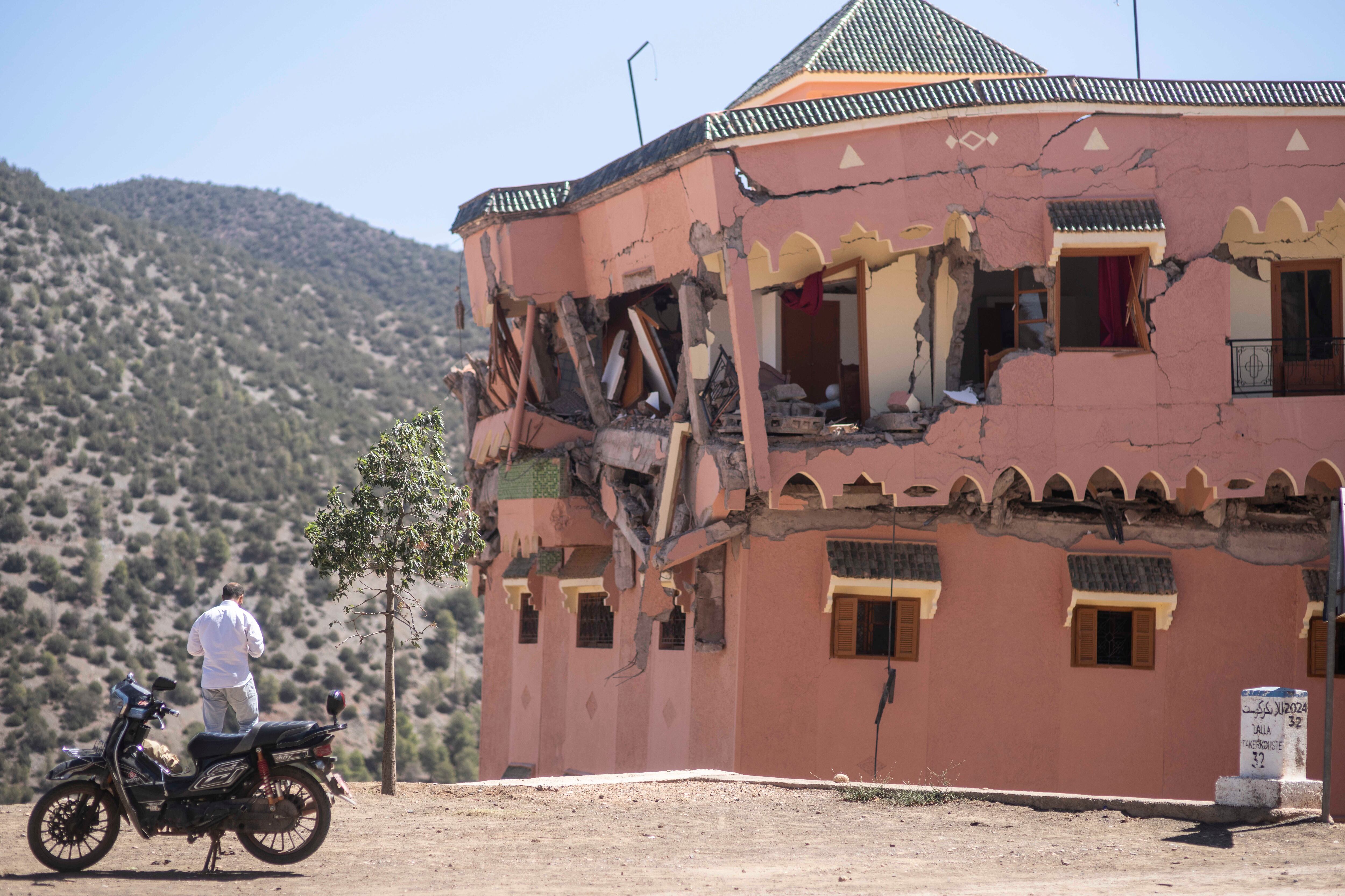 Un hombre de pie junto a un hotel dañado por un sismo en el poblado de Moulay Brahim, cerca del epicentro del sismo, a las afueras de Marrakech. (AP Foto/Mosa'ab Elshamy)