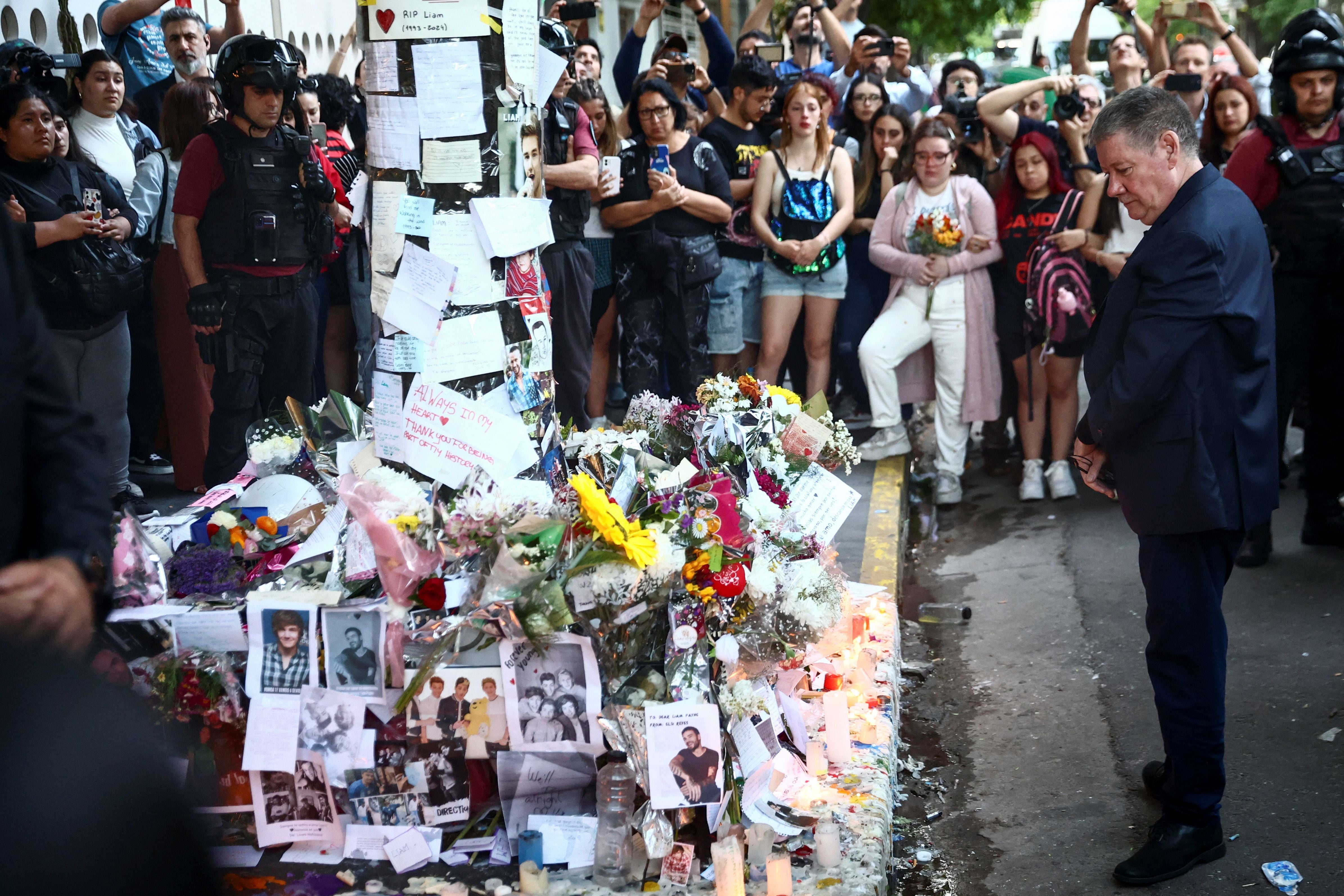 Geoff Payne, padre del exmiembro de la banda One Direction Liam Payne, observa los homenajes dejados fuera del hotel donde Liam Payne fue encontrado muerto después de caer desde el balcón de una habitación del tercer piso del hotel, en Buenos Aires, Argentina (REUTERS/Tomas Cuesta)