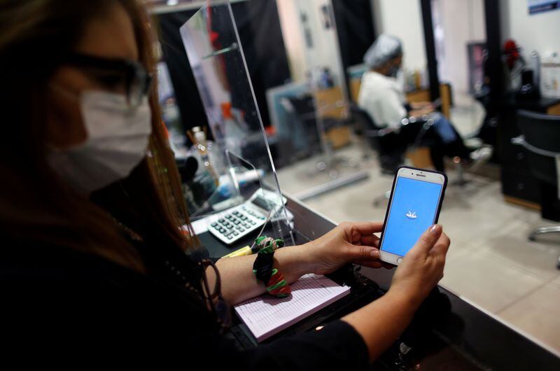 FOTO DE ARCHIVO. Imagen referencial de la dueña de una peluquería utilizando la app Mercado Pago, en Buenos Aires, Argentina. REUTERS/Agustín Marcarián