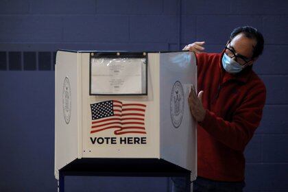 Un hombre desinfecta una máquina de votación anticipada en Nueva York (REUTERS / Andrew Kelly)