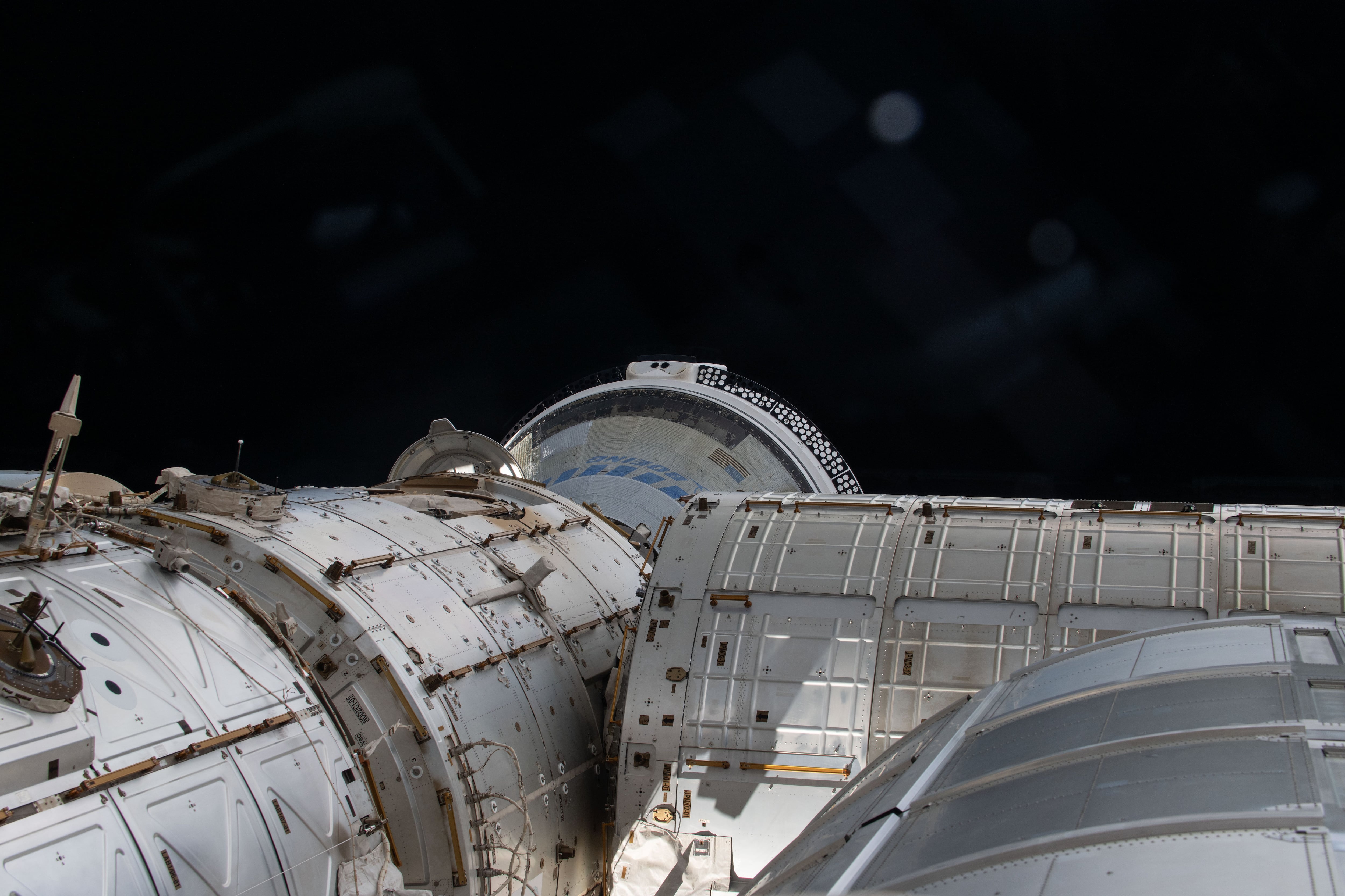 Fotografía cedida por la NASA el 13 de junio de 2024 de una instantánea tomada el día 6 de junio desde una ventana donde se muestra en una parte el espacio y la nave espacial Starliner de Boeing, atracada en el puerto delantero del módulo Harmony en la Estación Espacial Internacional (EEI). EFE/NASA
