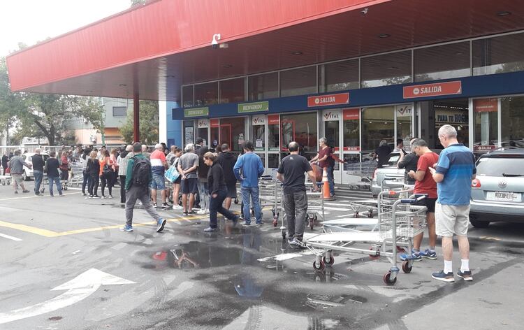 Las personas deben esperar su turno para ingresar a los supermercados (foto Maximiliano Luna)