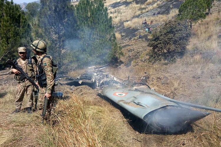 Tropas de Pakistán custodian los restos de un Mig-21 indio derribado (Photo by STR / AFP)