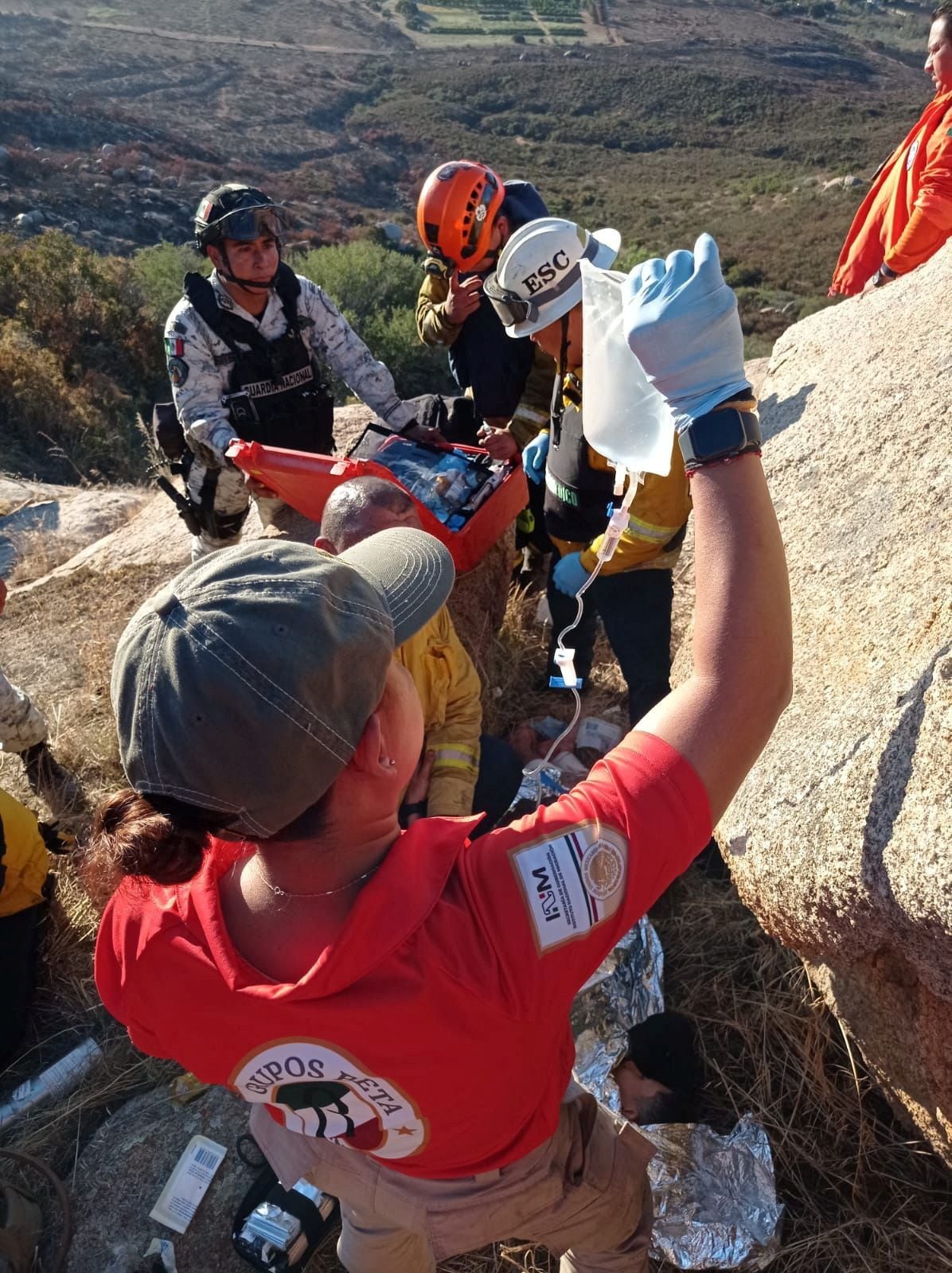 Members of the Mexican immigrant welfare agency Grupo Beta help a person injured during an armed attack by unknown assailants early Friday, at the Cerro de Cuchuma, in Tecate, in Baja California state, Mexico, in this handout picture distributed to Reuters on September 29, 2023. Mexico's National Institute of Migration (INM)/Handout via REUTERS THIS IMAGE HAS BEEN SUPPLIED BY A THIRD PARTY. NO RESALES. NO ARCHIVES.