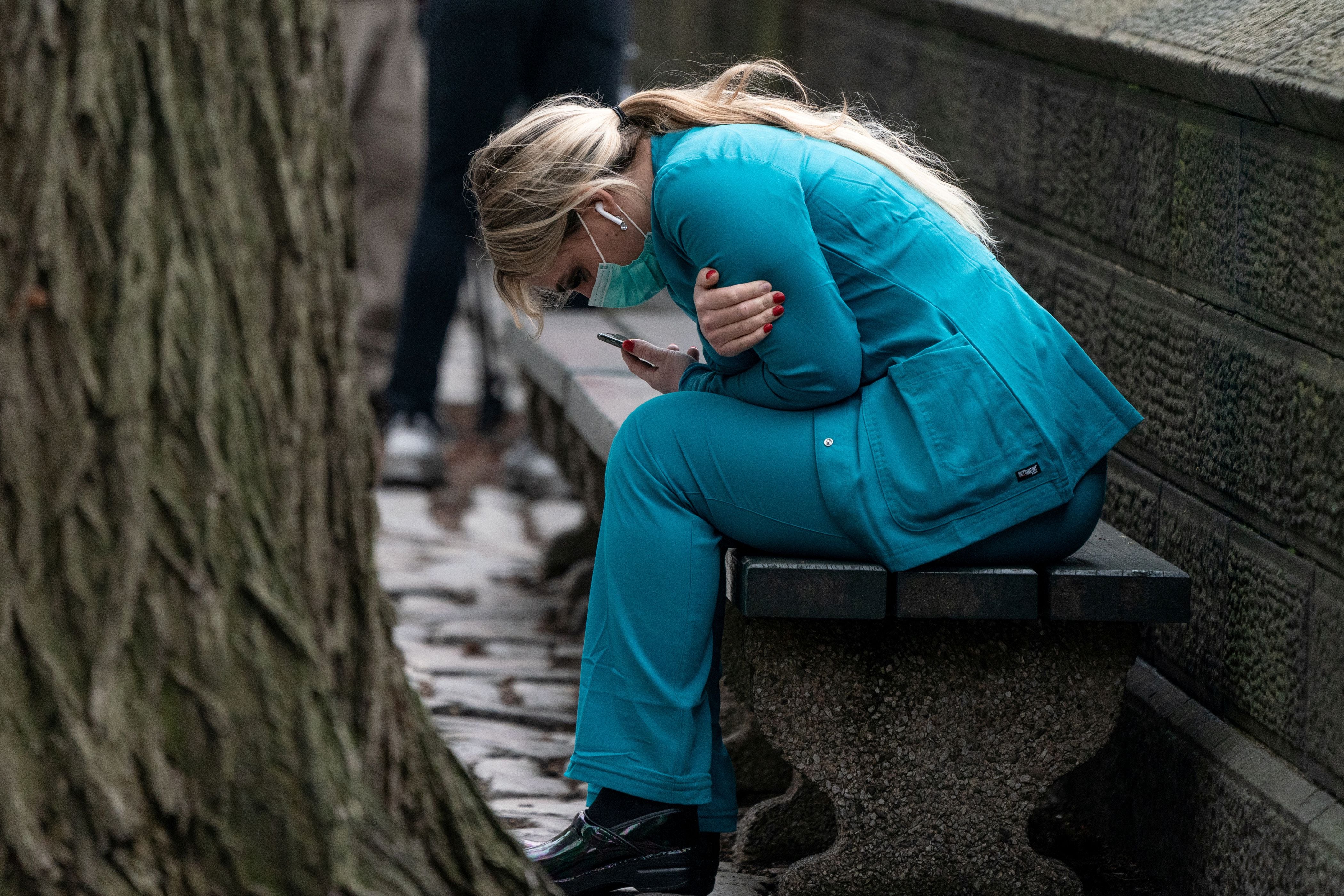 Una empleada sanitaria descansa en una banca de Central Park, en Nueva York (Reuters)