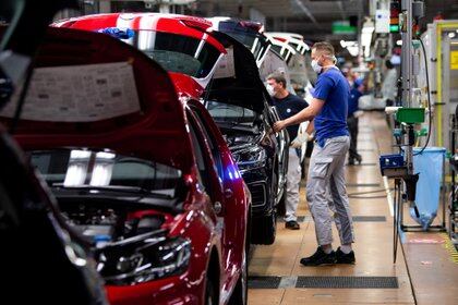 Un trabajador usa una máscara protectora en la línea de la fábrica de automóviles más grande de Europa, el 27 de abril de 2020 (Swen Pfoertner/Pool vía REUTERS/Archivo Foto)