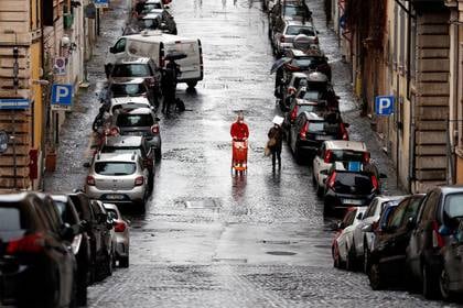 Un hombre con una mascarilla empuja un carrito de la compra en una calle casi vacía durante el brote de la enfermedad coronavirus (COVID-19) en Roma, Italia, el 26 de marzo, 2020 (REUTERS/Yara Nardi)