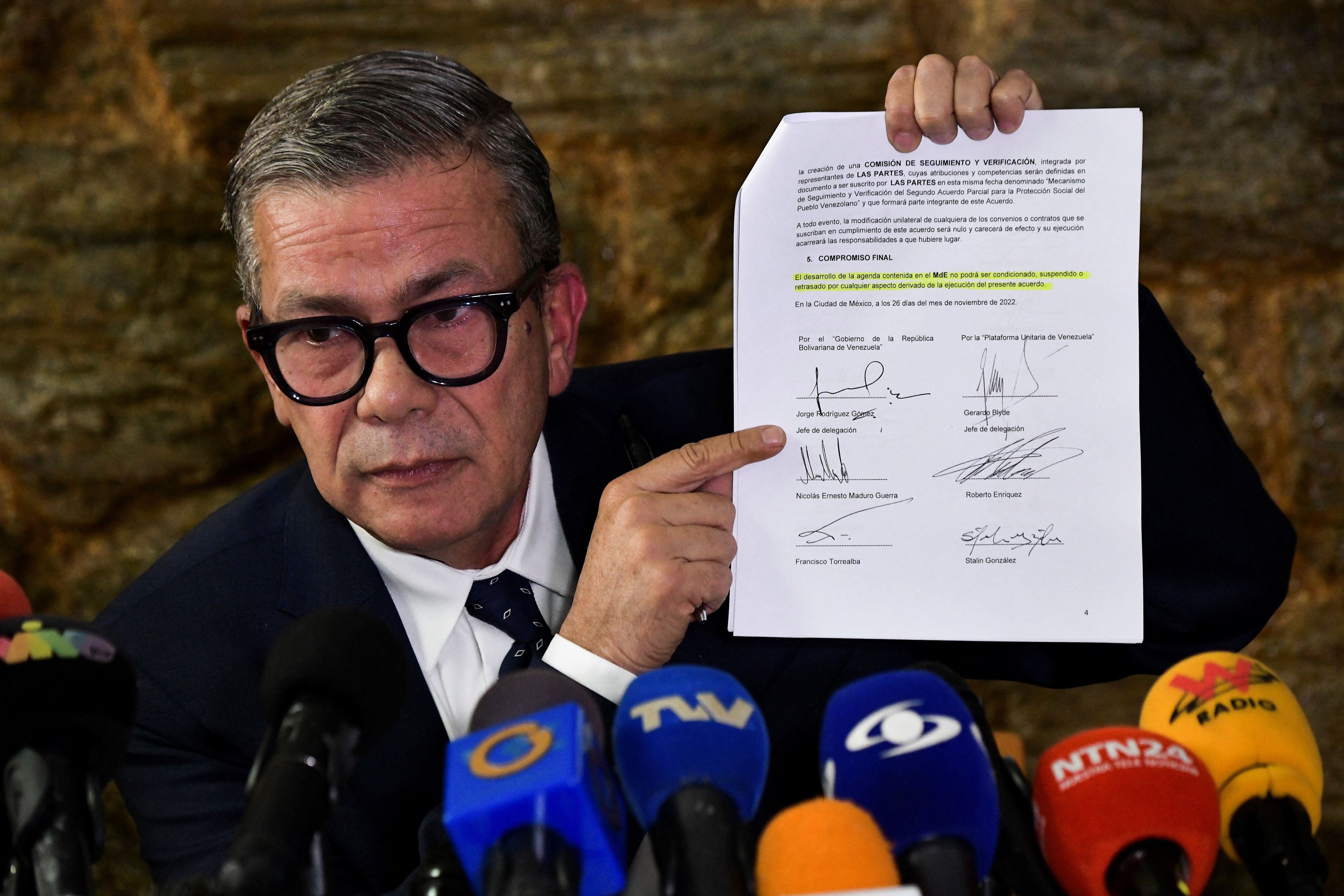 Gerardo Blyde, jefe de la delegación de la oposición venezolana, muestra un documento firmado durante las negociaciones. REUTERS/Gaby Oraa