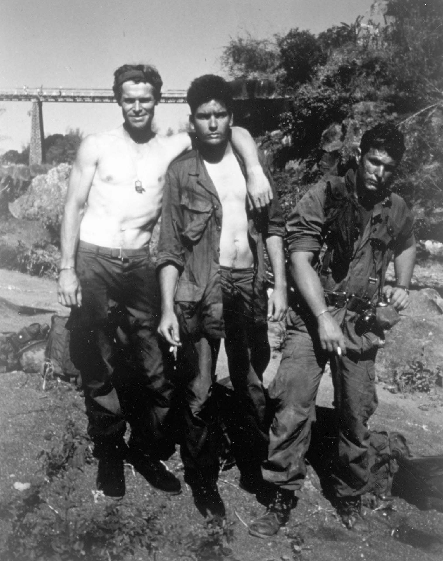 1986, los actores estadounidenses Willem Dafoe, Charlie Sheen y Tom Berenger posan al aire libre en el set de la película del director Oliver Stone, 'Platoon'  (Photo by Orion Pictures/Getty Images)