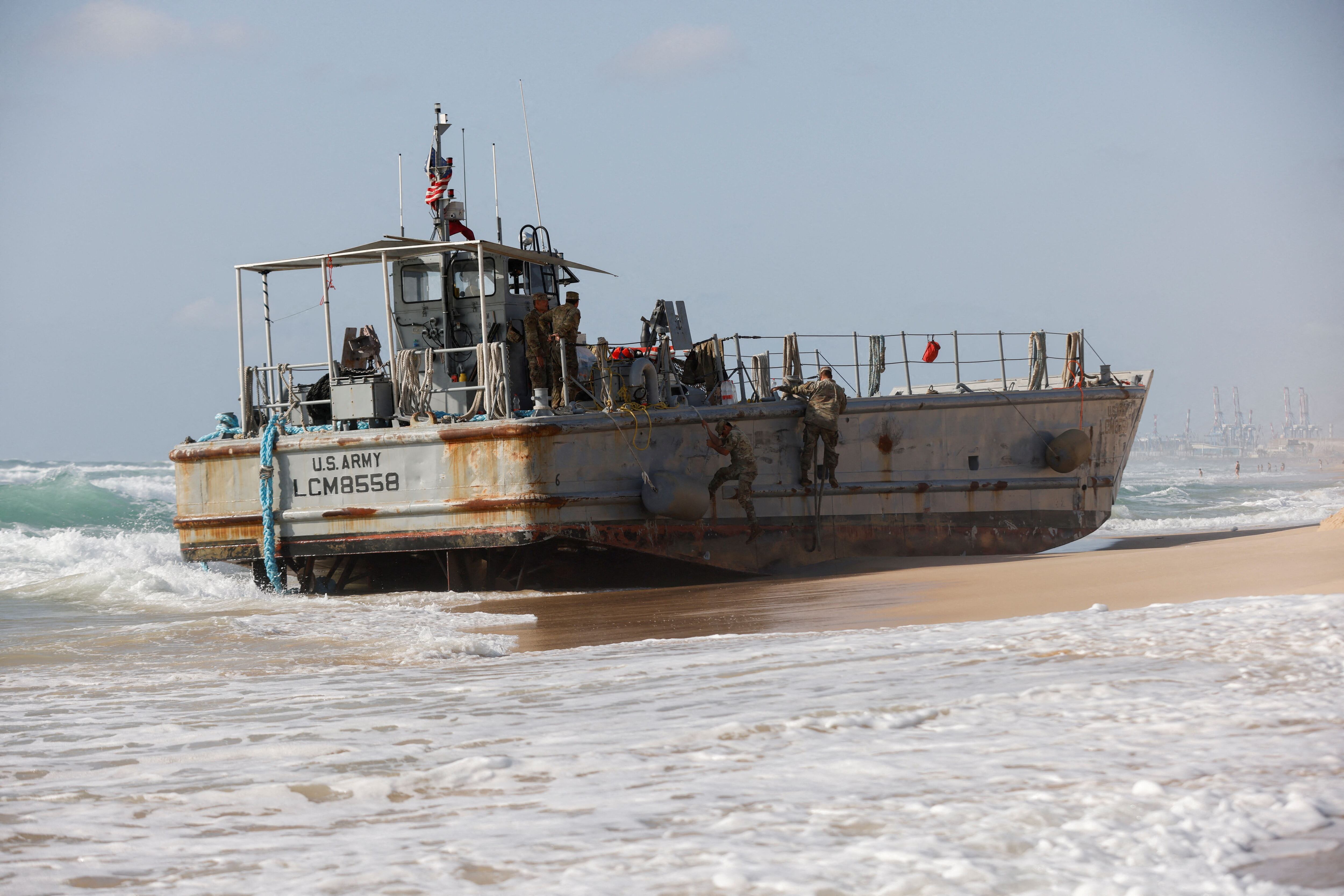 Tropas estadounidenses suben a un barco encallado utilizado para entregar ayuda a los palestinos a través de un nuevo muelle construido por Estados Unidos en Gaza, después de que encallara junto con otro barco de ayuda en la orilla del Mediterráneo en Ashdod, Israel, este 25 de mayo de 2024 (REUTERS/Amir Cohen)