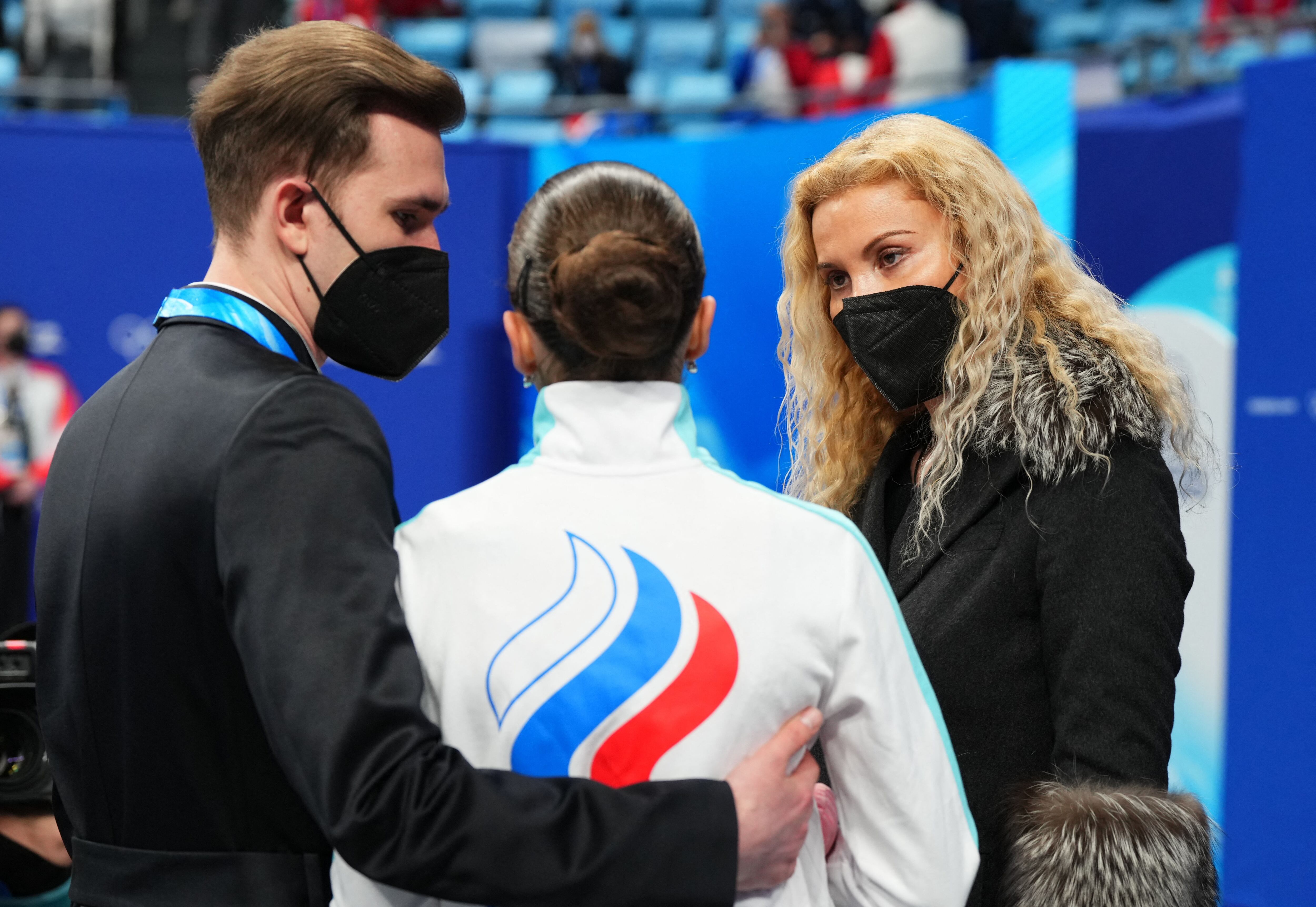 2022 Beijing Olympics - Figure Skating - Women Single Skating - Free Skating - Capital Indoor Stadium, Beijing, China - February 17, 2022. Kamila Valieva of the Russian Olympic Committee reacts after competing with coaches Eteri Tutberidze and Daniil Gleikhengauz of the Russian Olympic Committee. REUTERS/Aleksandra Szmigiel