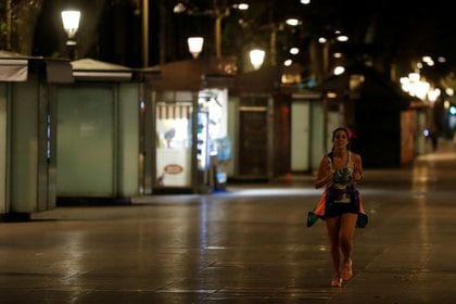 A woman runs on Las Ramblas during the first day of the night curfew, part of an effort to control the outbreak of coronavirus disease (COVID-19), in Barcelona, ​​Spain.  October 25, 2020. REUTERS / Nacho Doce
