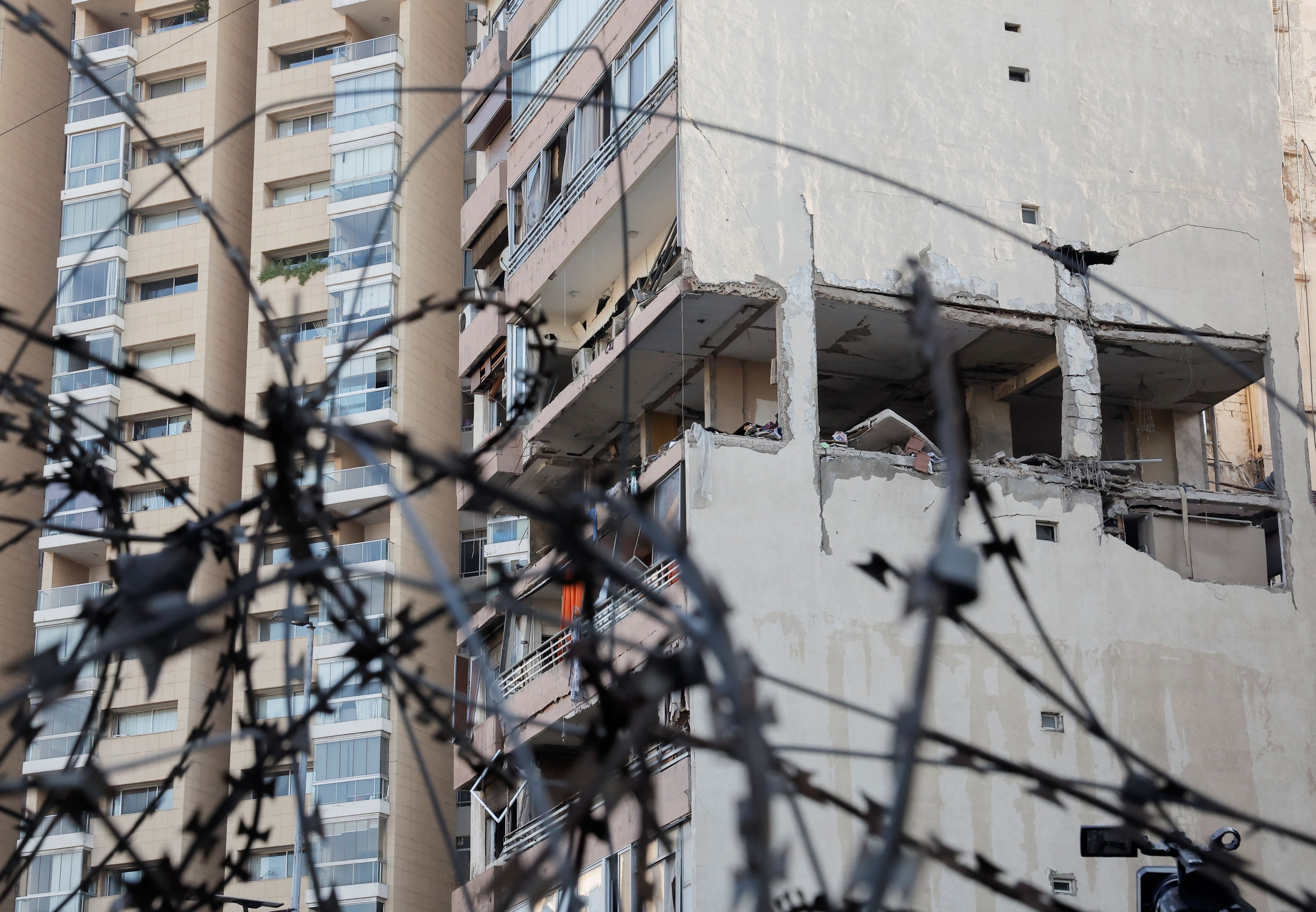 Un edificio dañado en un ataque israelí se ve a través de una valla de alambre de púas en el centro de Beirut, Líbano este 30 de septiembre (Reuters)